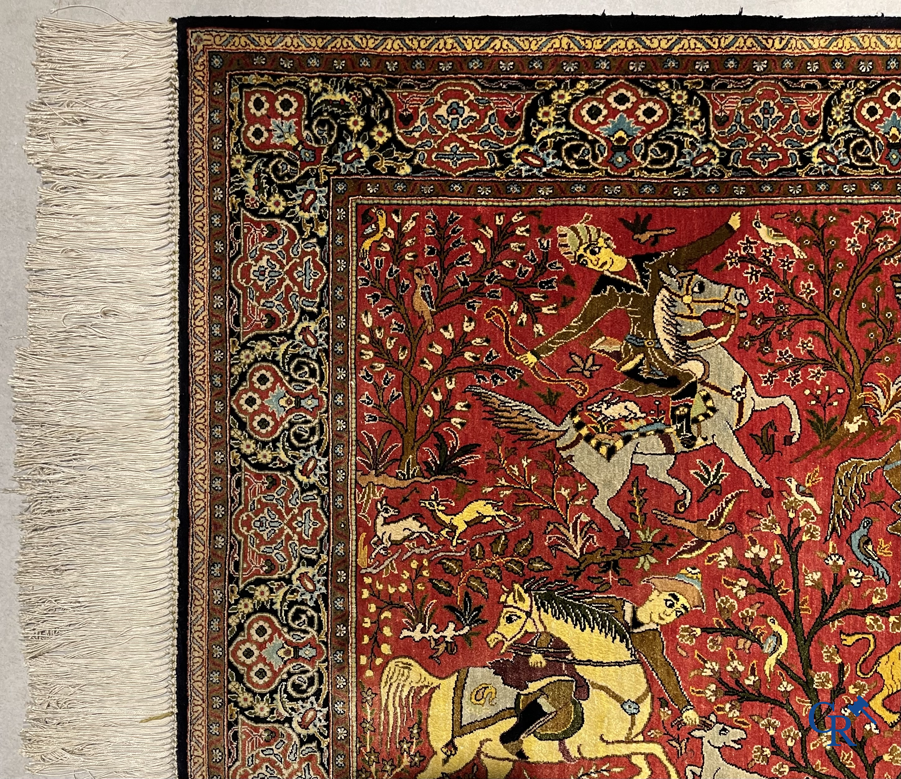 Oriental carpets, a Persian carpet in silk with a scene of hunters on horseback.