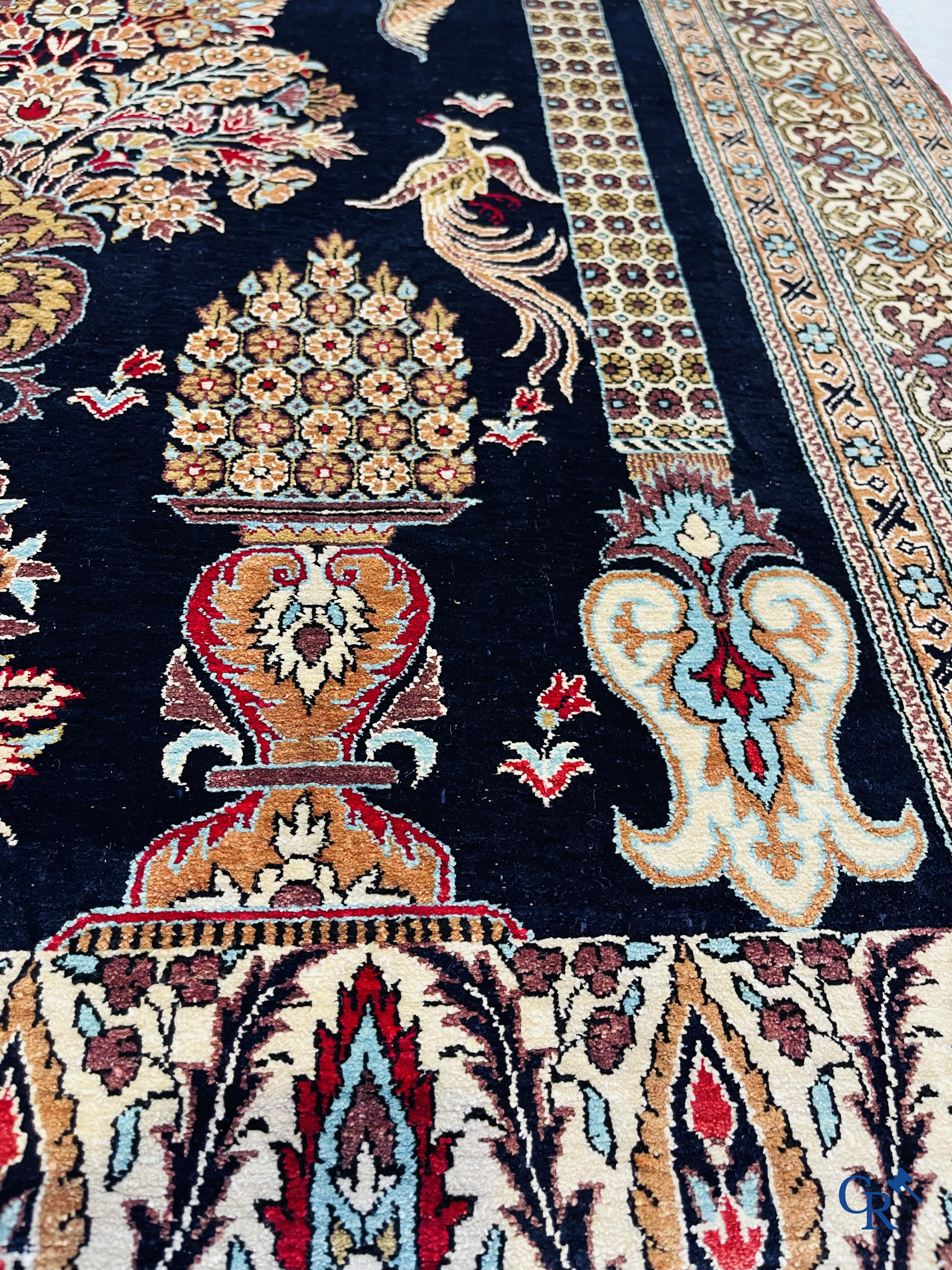 Persian carpets: A finely knotted silk Ghoum carpet with a decor of birds and flowers.