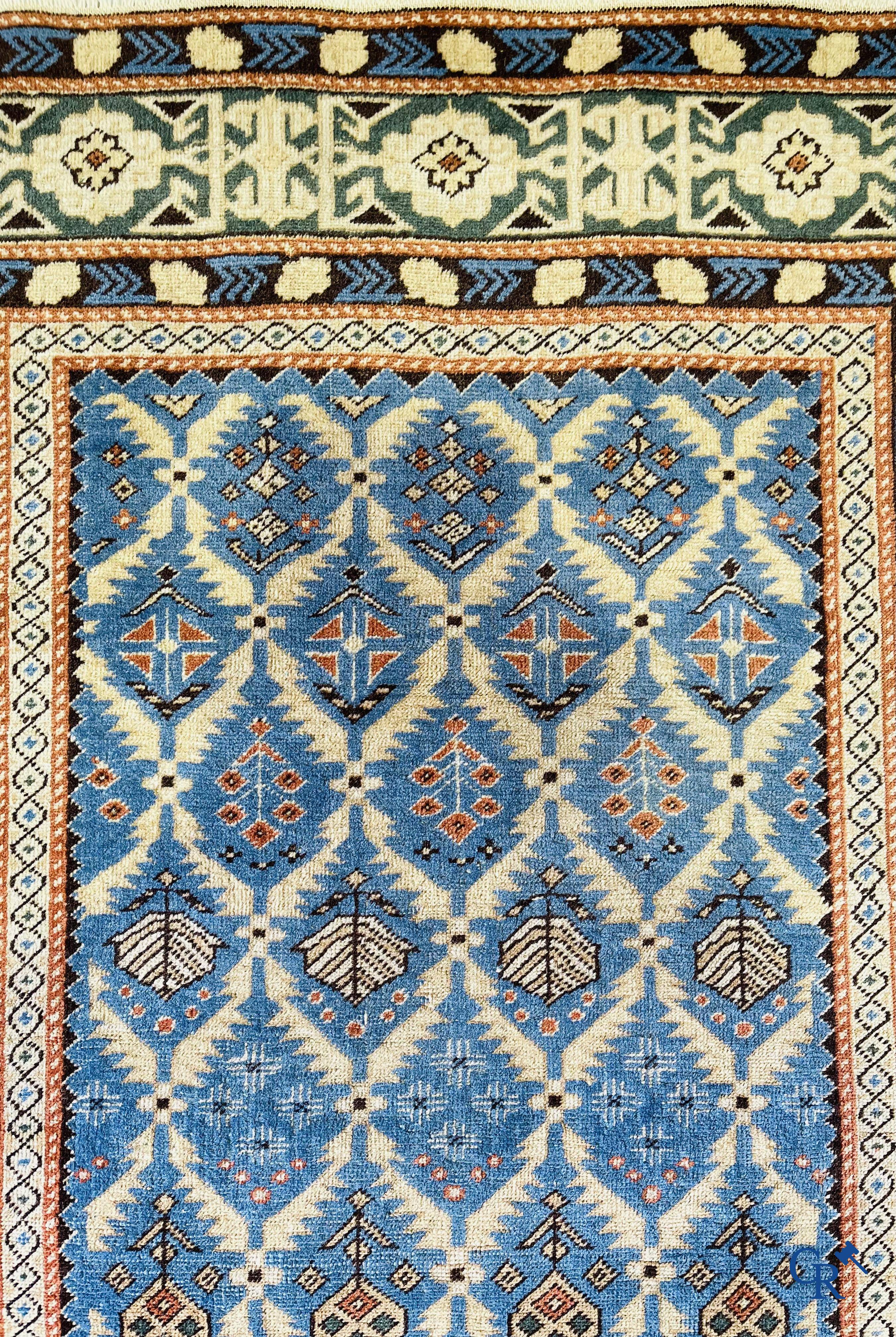 Antique Oriental carpets, an antique Dagestan carpet with motifs on a blue background.