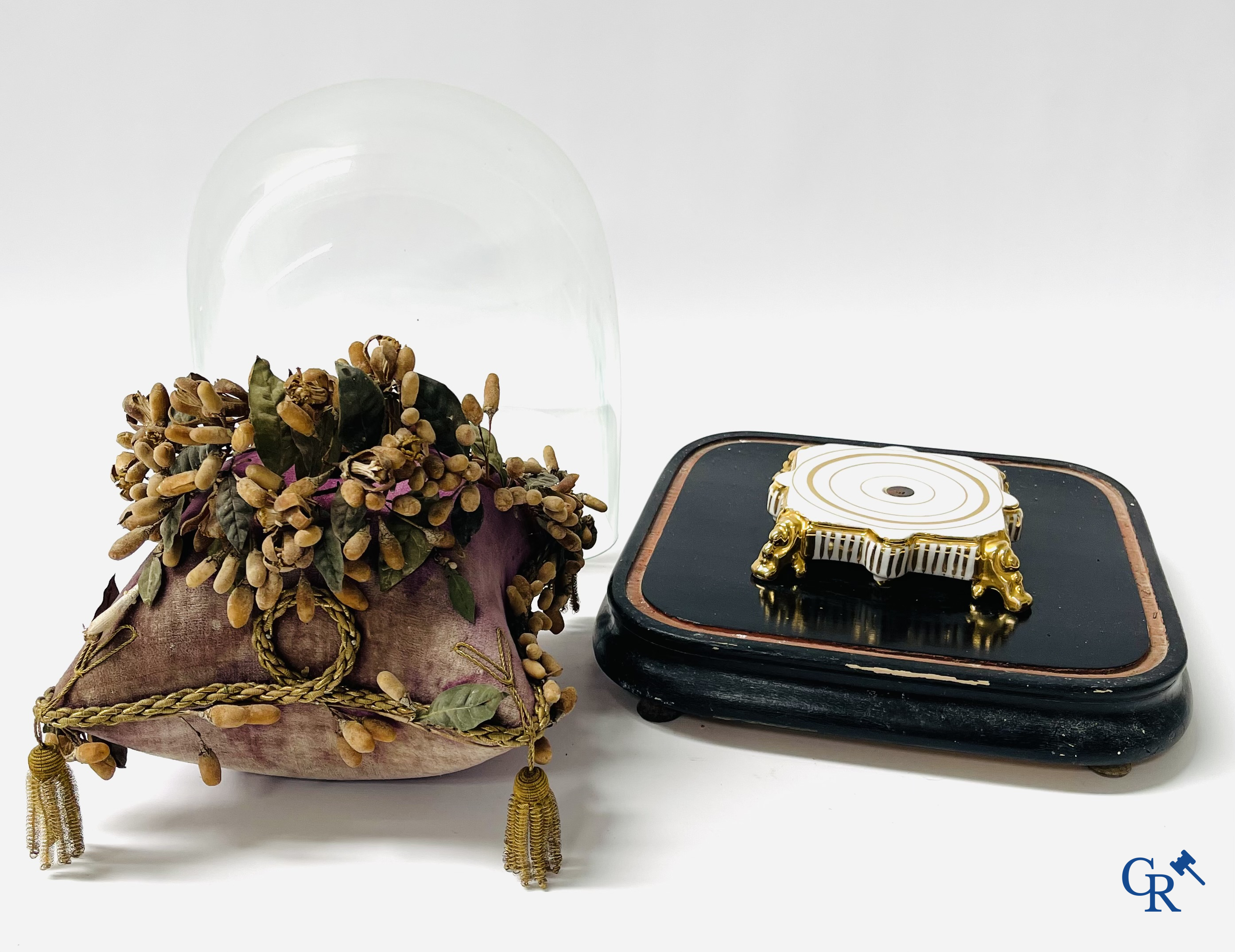 2 globes en verre avec un bouquet de mariée sur un coussin avec un pied en métal doré et un pied en porcelaine de Paris.