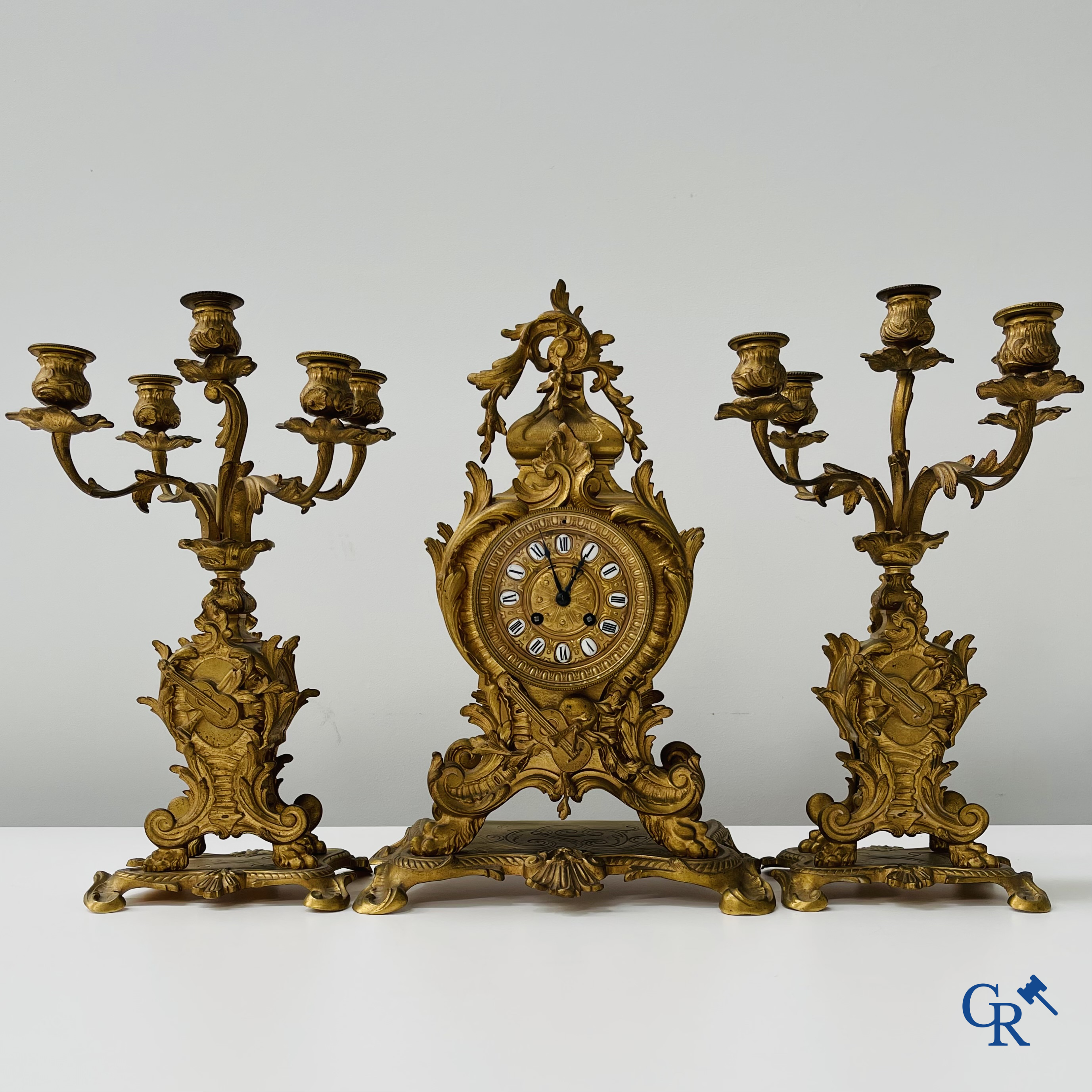 Garniture de cheminée en bronze doré. Cadran en bronze avec chiffres romains émaillés. Style LXV. Vers 1900.