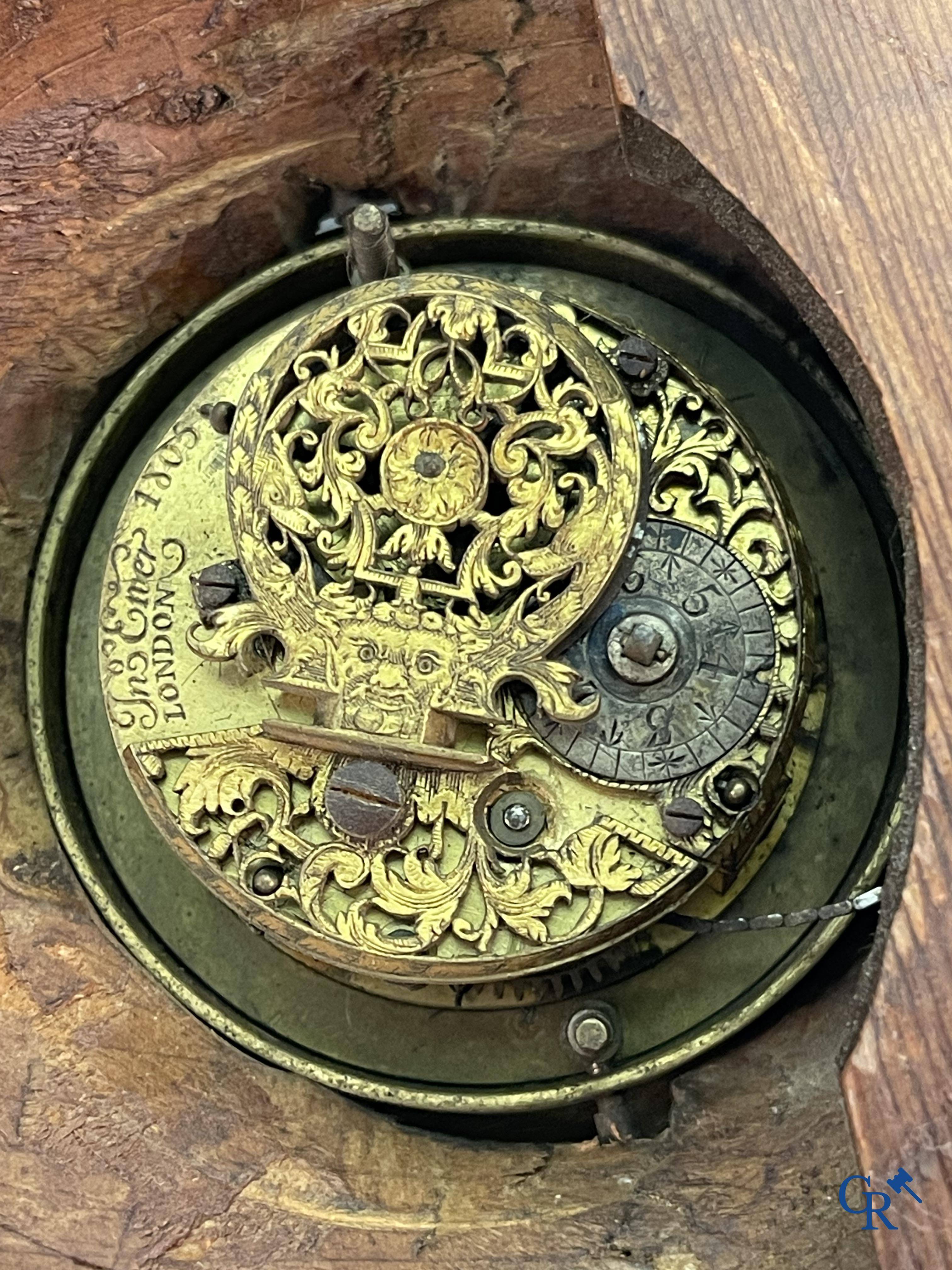 An 18th century wood carved table clock with finely chiseled English watchwork.