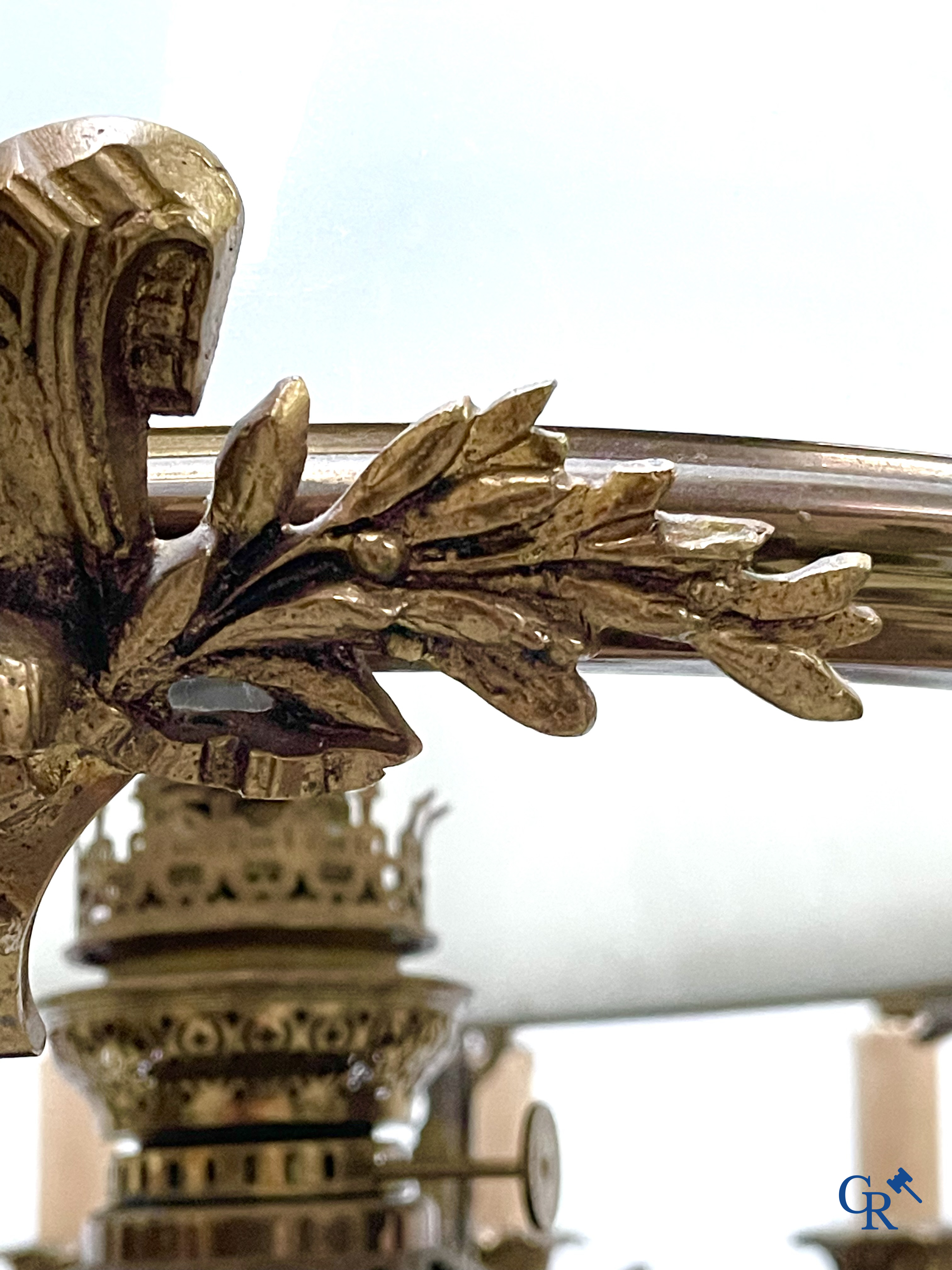 A lot of an imposing chandelier with 12 light points, a lamp belge with bronze frame and a fireplace piece.