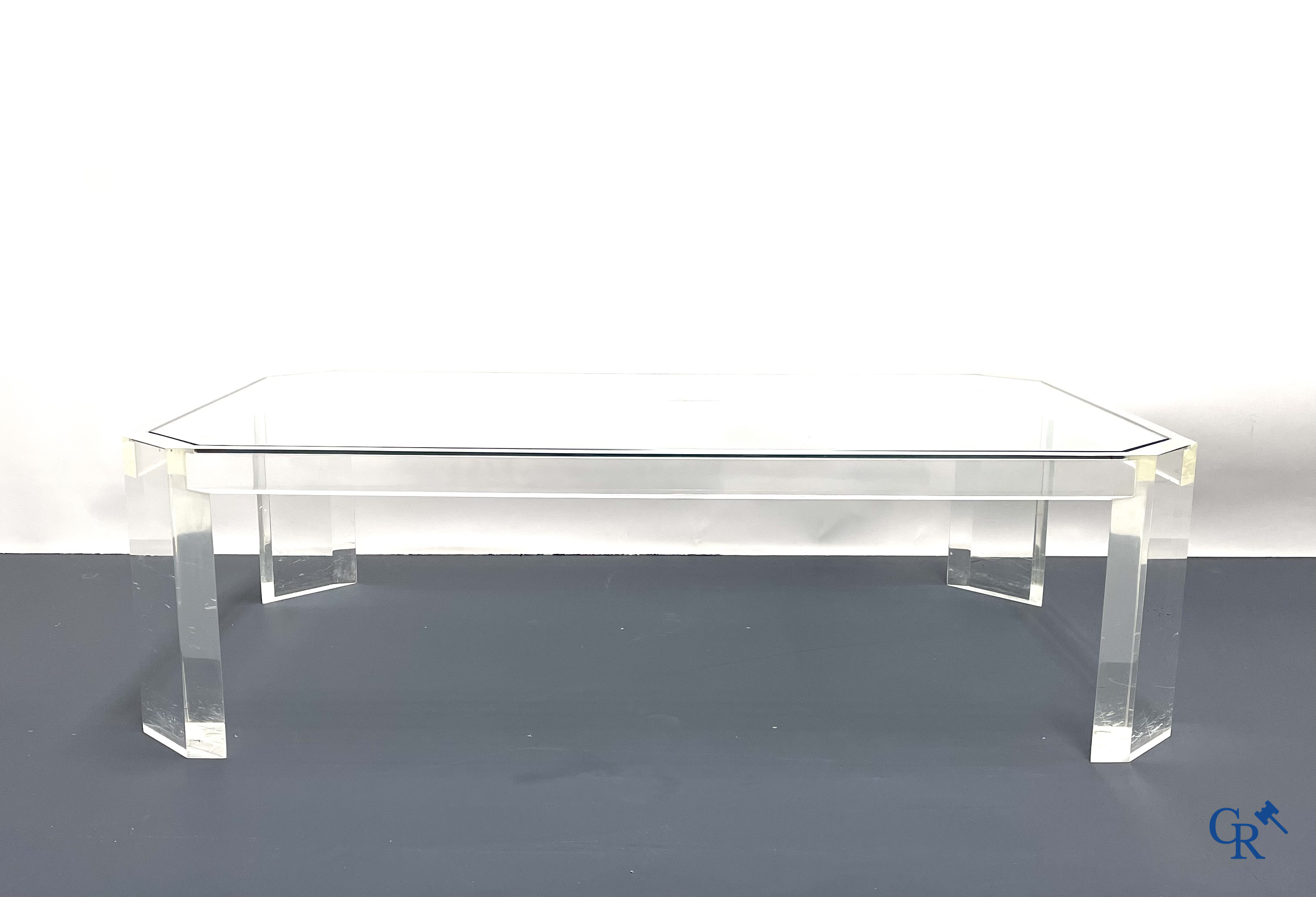 Une table basse en plexiglas avec une tablette en verre. Vers 1980.