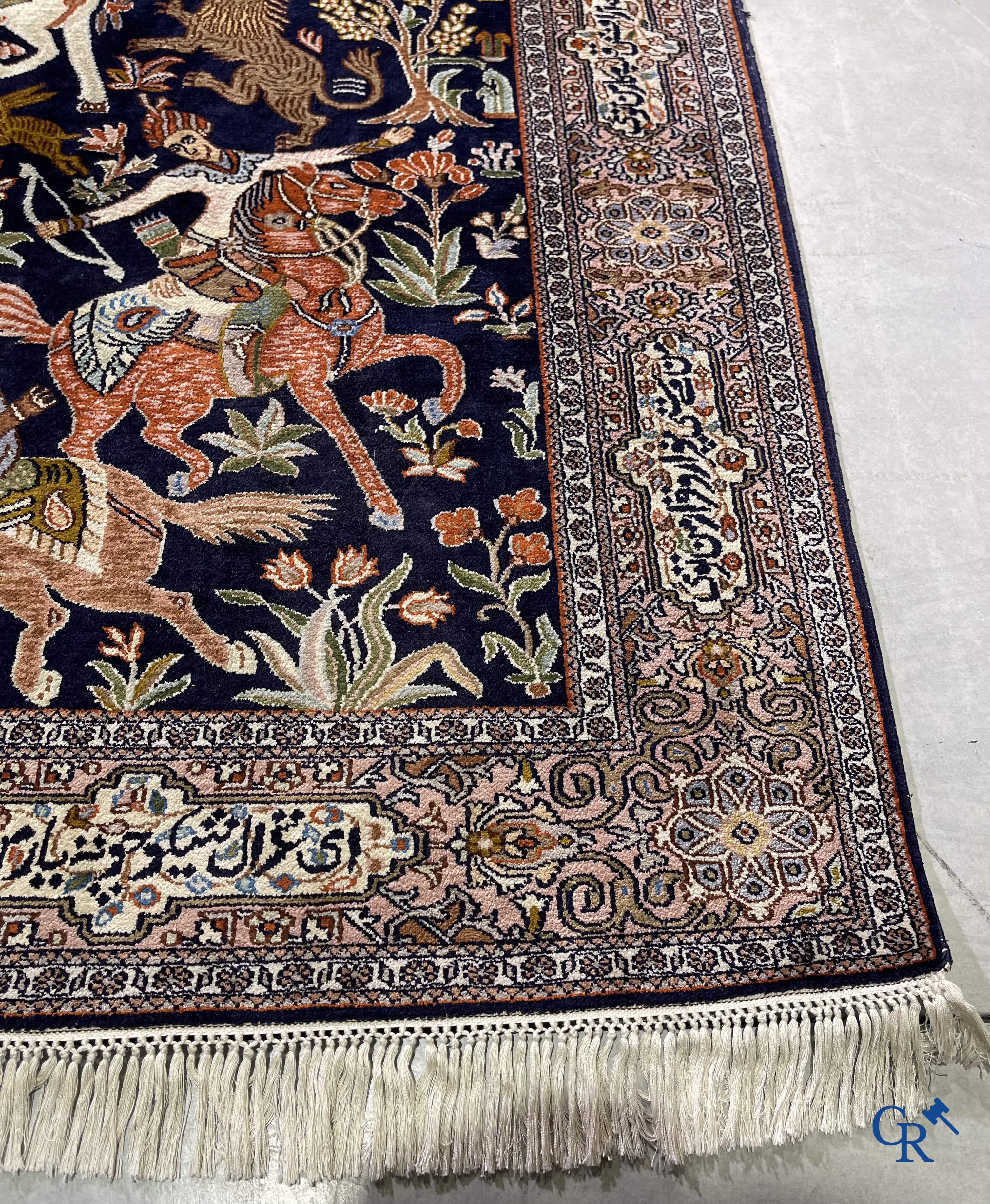 Oriental rugs. Iran. A finely hand-knotted Persian rug in wool and silk with hunters on horseback and inscriptions.