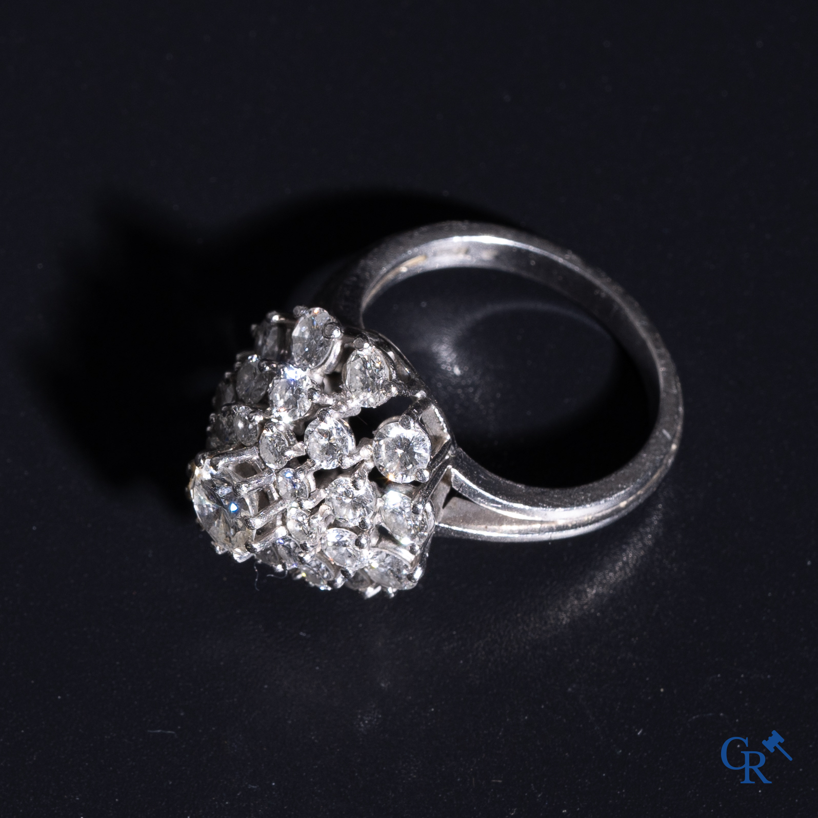 Juwelen: Pompadour ring in Platinum bezet met een centrale diamant van ongeveer 0,75 ct en 30 kleine diamantjes.