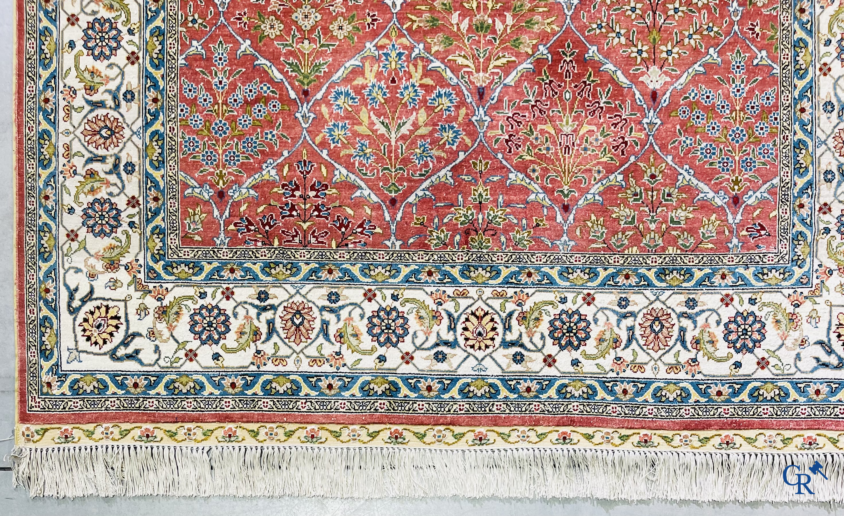 Tapis d'Orient: Un tapis finement noué à la main en laine et soie avec un décor floral.<br />
Signé.