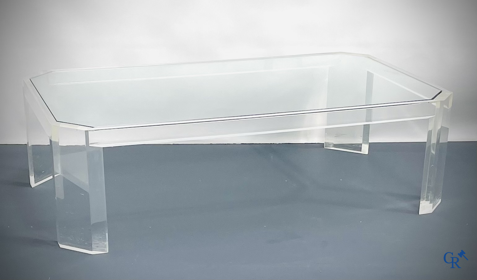 Une table basse en plexiglas avec une tablette en verre. Vers 1980.