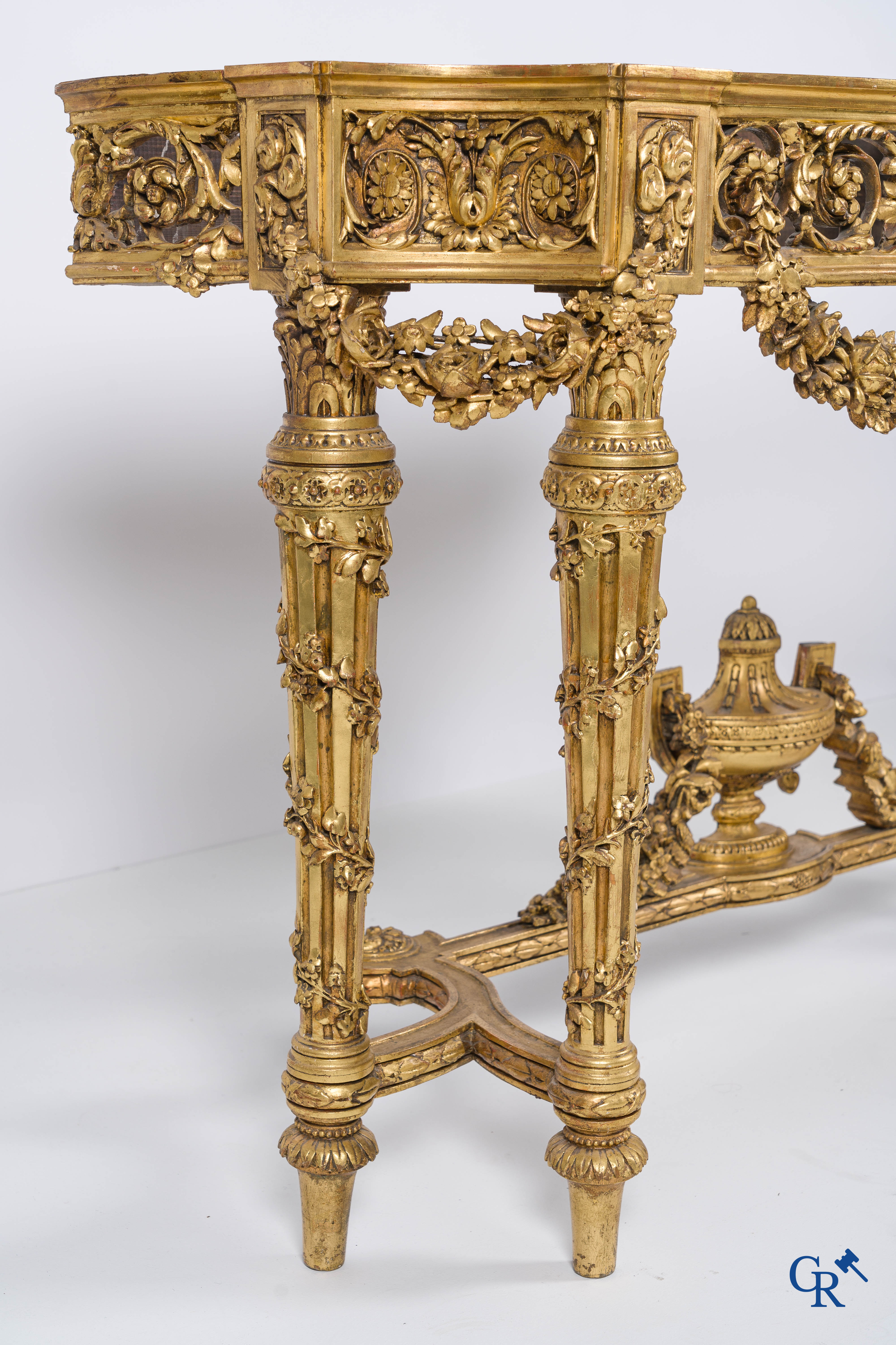 A richly carved and gilded console table in LVXI style with a grisaille painting on marble.