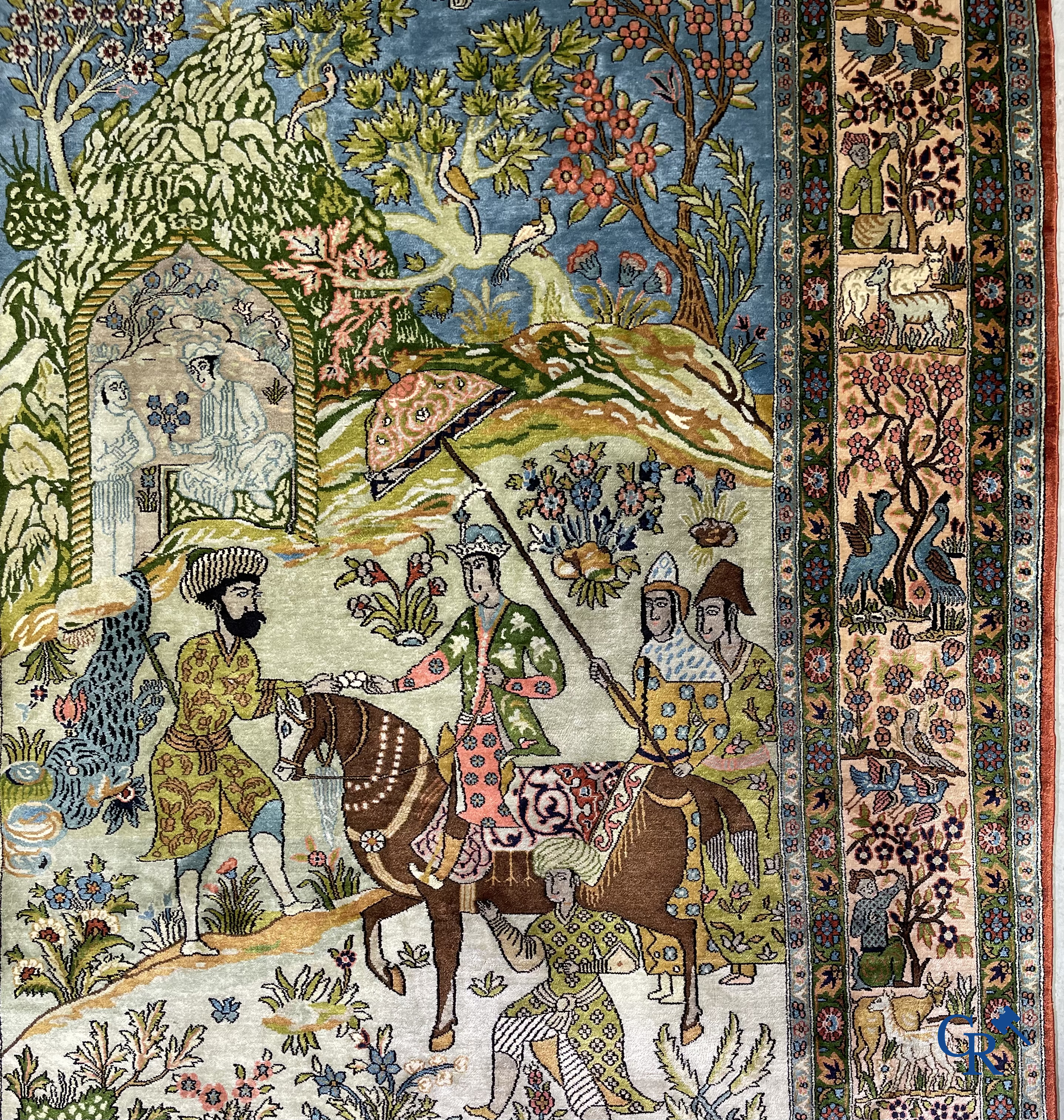 Tapis d'Orient. Iran. Un tapis persan en soie finement noué à la main avec des personnages et un cheval dans un paysage.