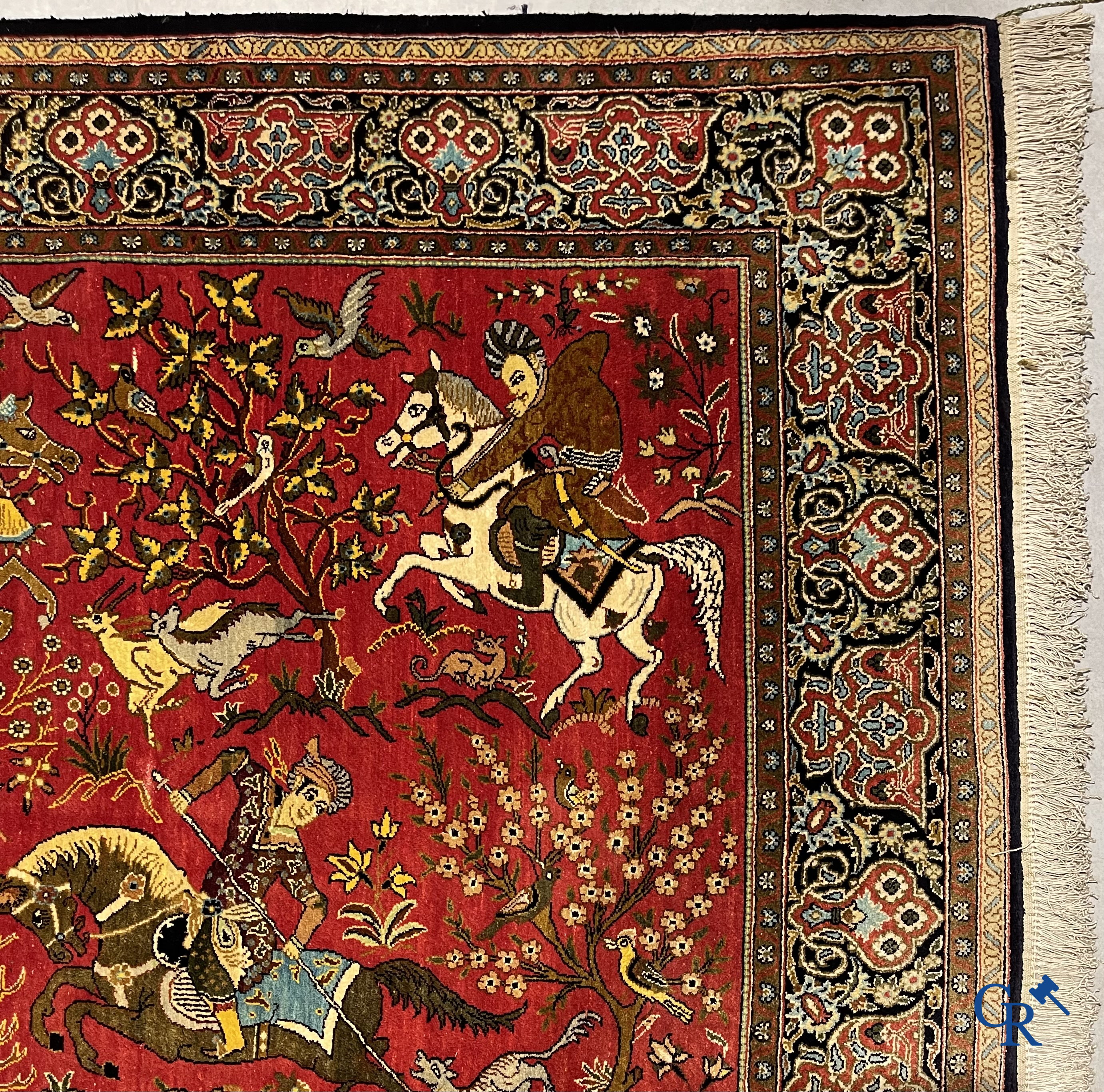 Oriental carpets, a Persian carpet in silk with a scene of hunters on horseback.