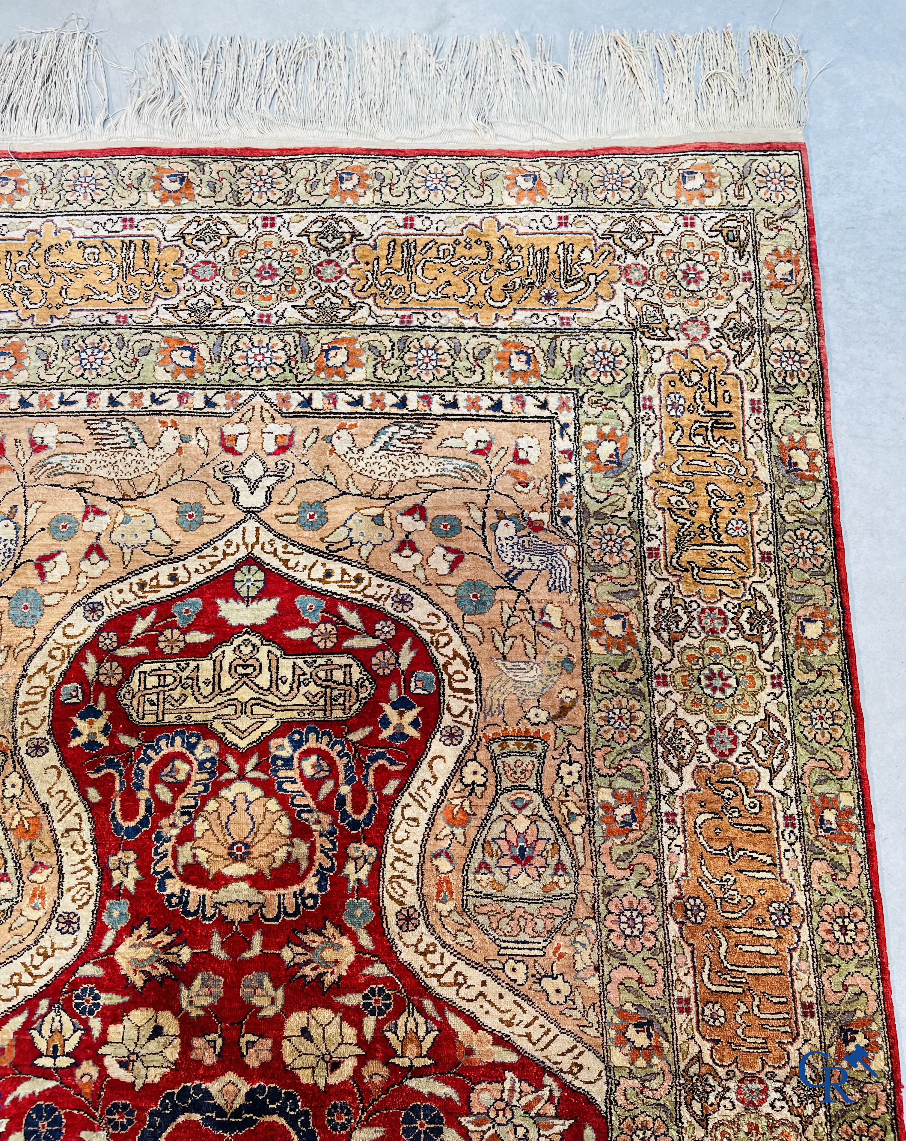 Oriental carpets: Hereke, a finely knotted silk carpet with inscriptions and birds in a floral decor.