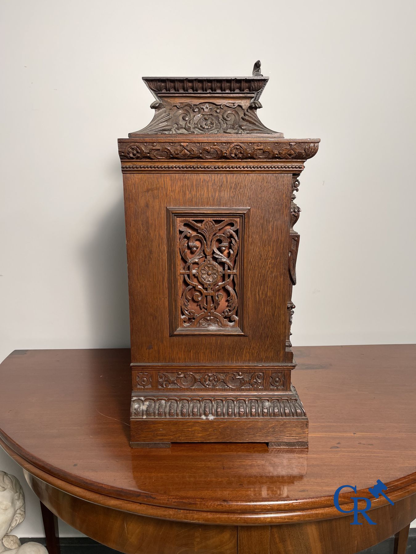 Clock with multiple bells and music in oak sculpted case with matching pedestal.