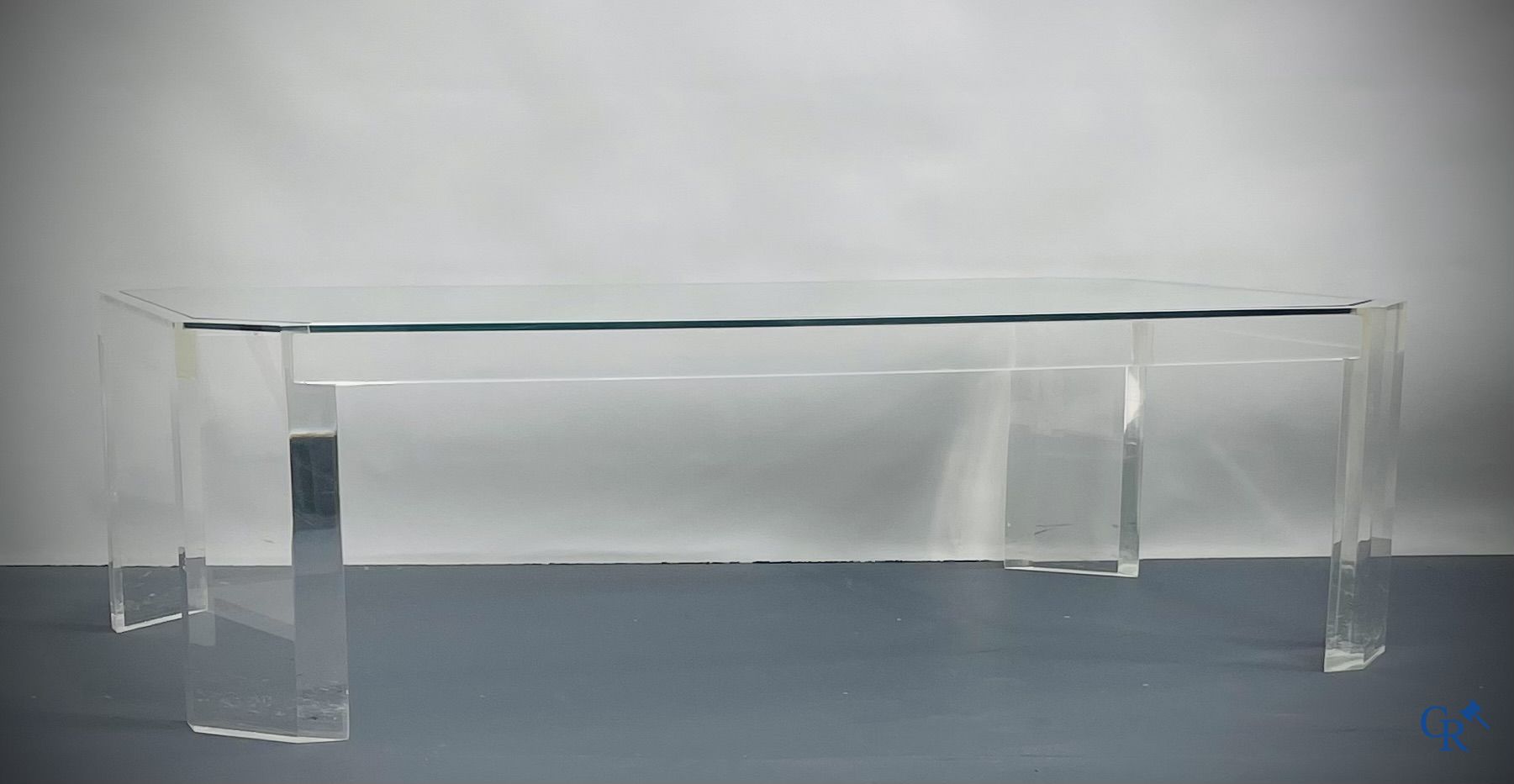 Une table basse en plexiglas avec une tablette en verre. Vers 1980.