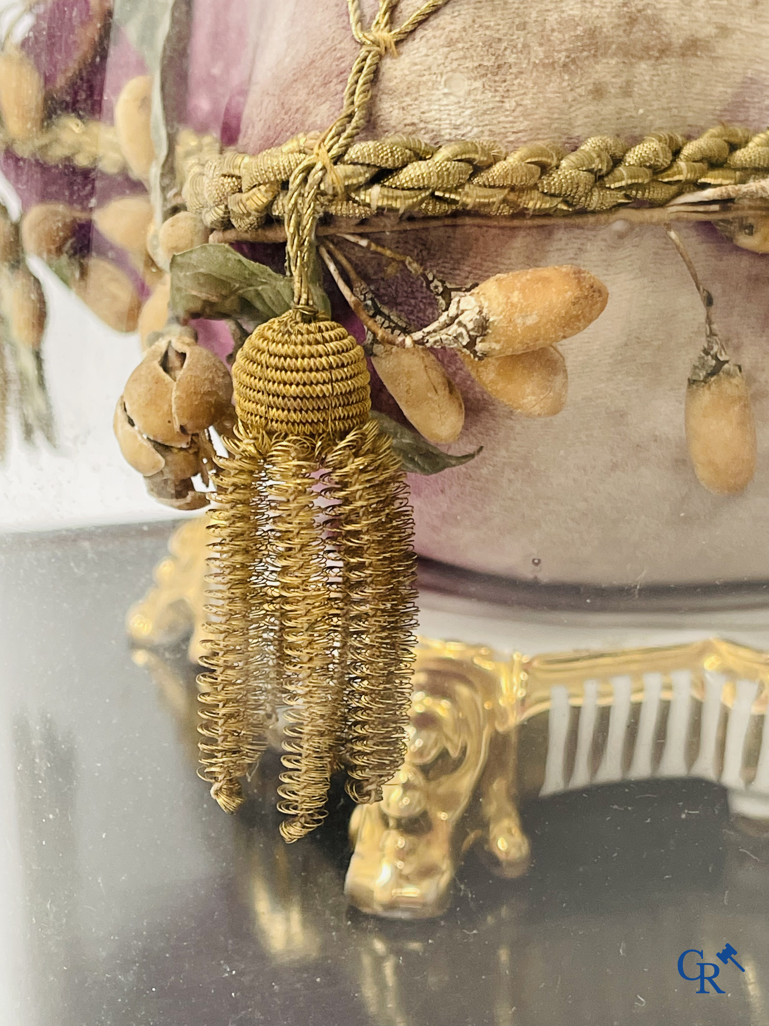 2 globes en verre avec un bouquet de mariée sur un coussin avec un pied en métal doré et un pied en porcelaine de Paris.