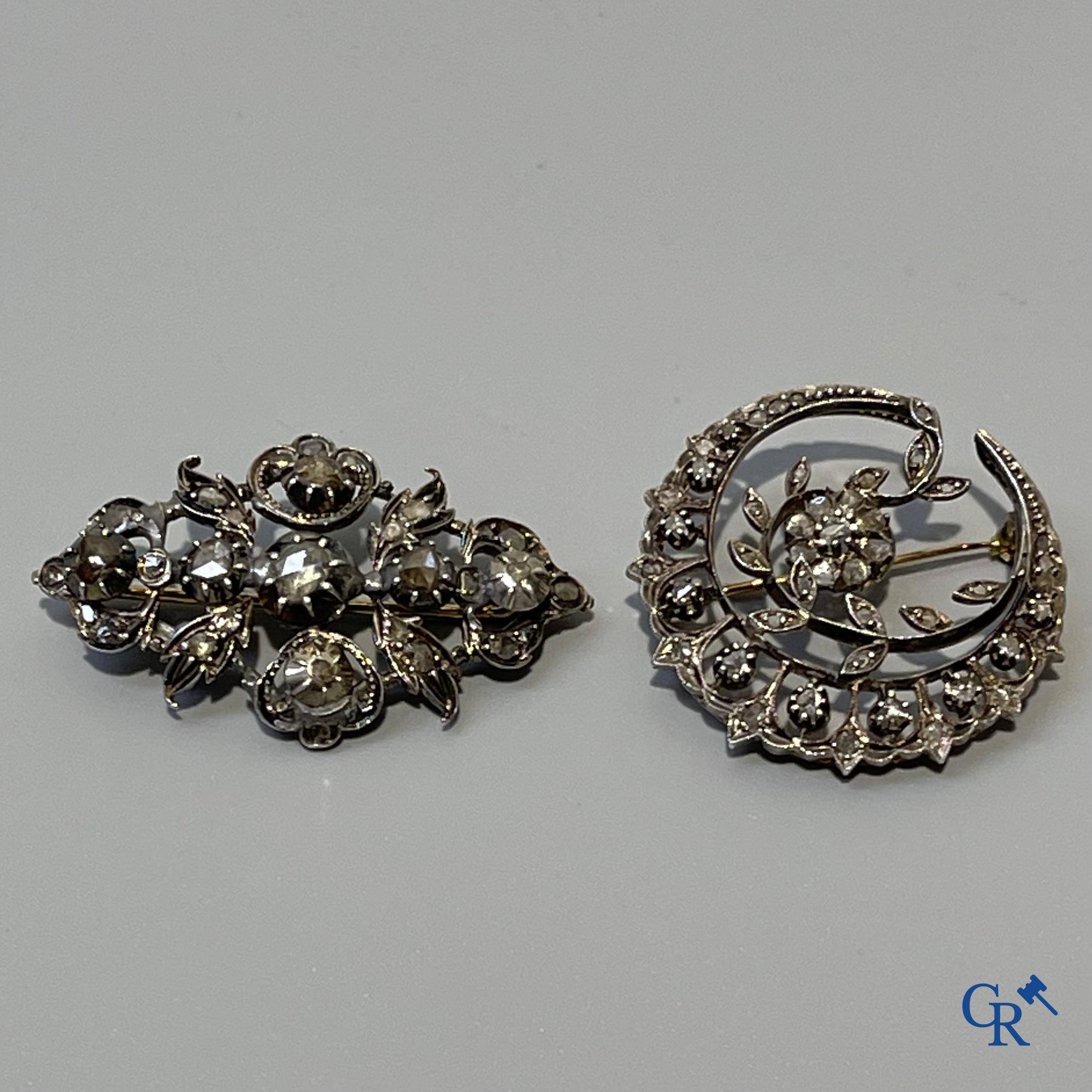 Juwelen, 2 broches in goud 750°/00 en zilver bezet met diamanten, oude slijp. Grootste steen +- 0,5 ct.