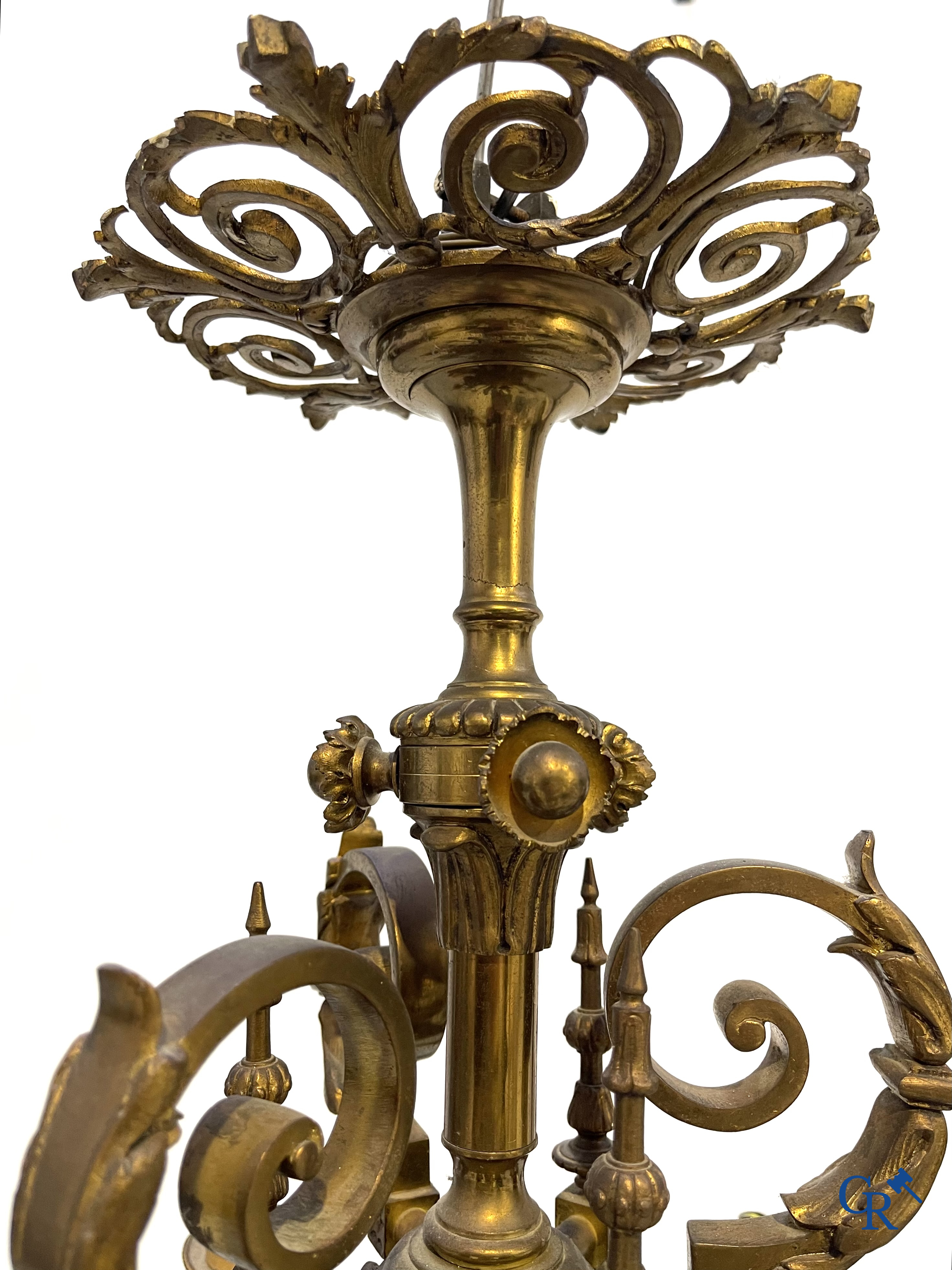 A lot of an imposing chandelier with 12 light points, a lamp belge with bronze frame and a fireplace piece.