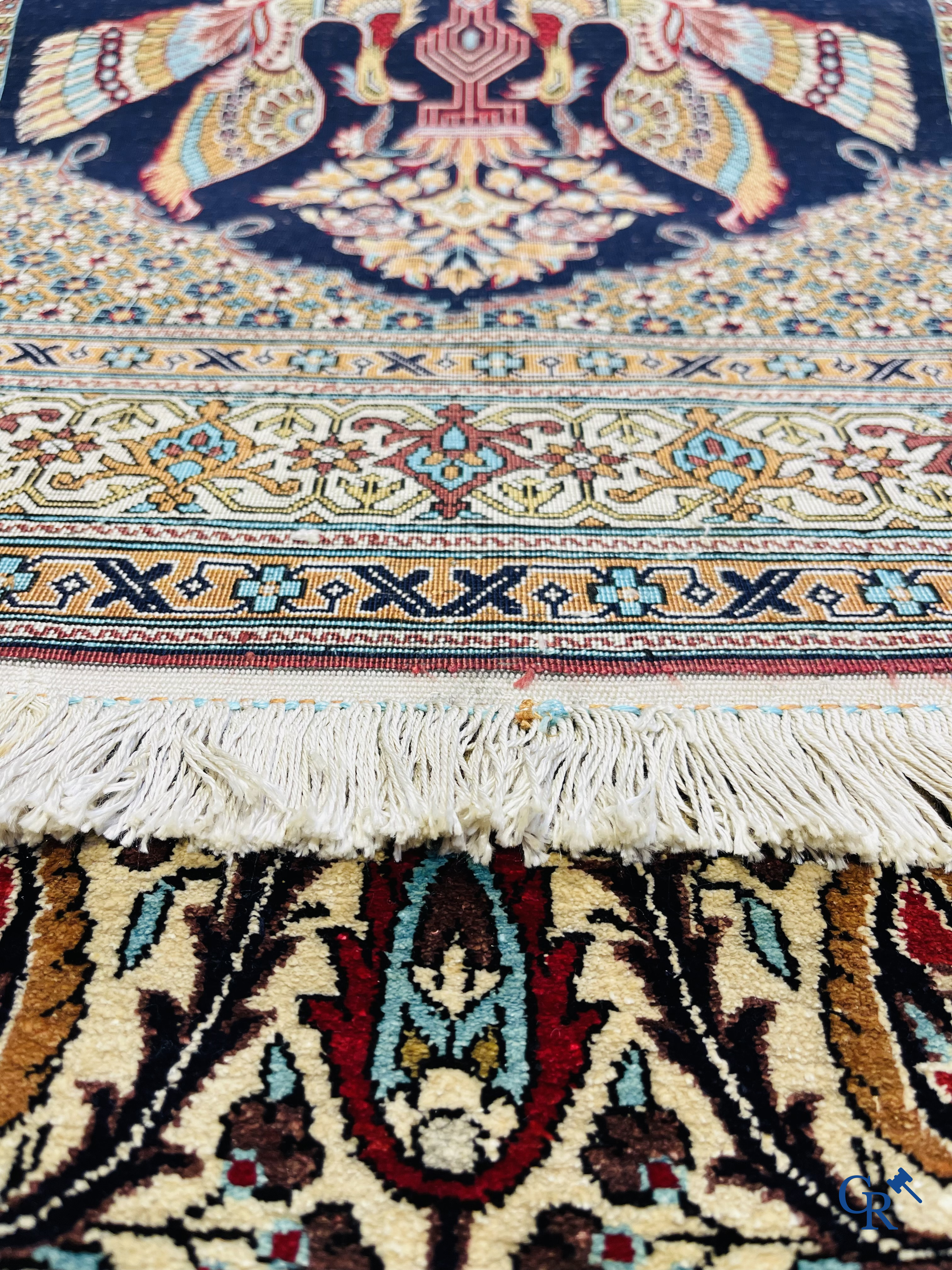 Persian carpets: A finely knotted silk Ghoum carpet with a decor of birds and flowers.