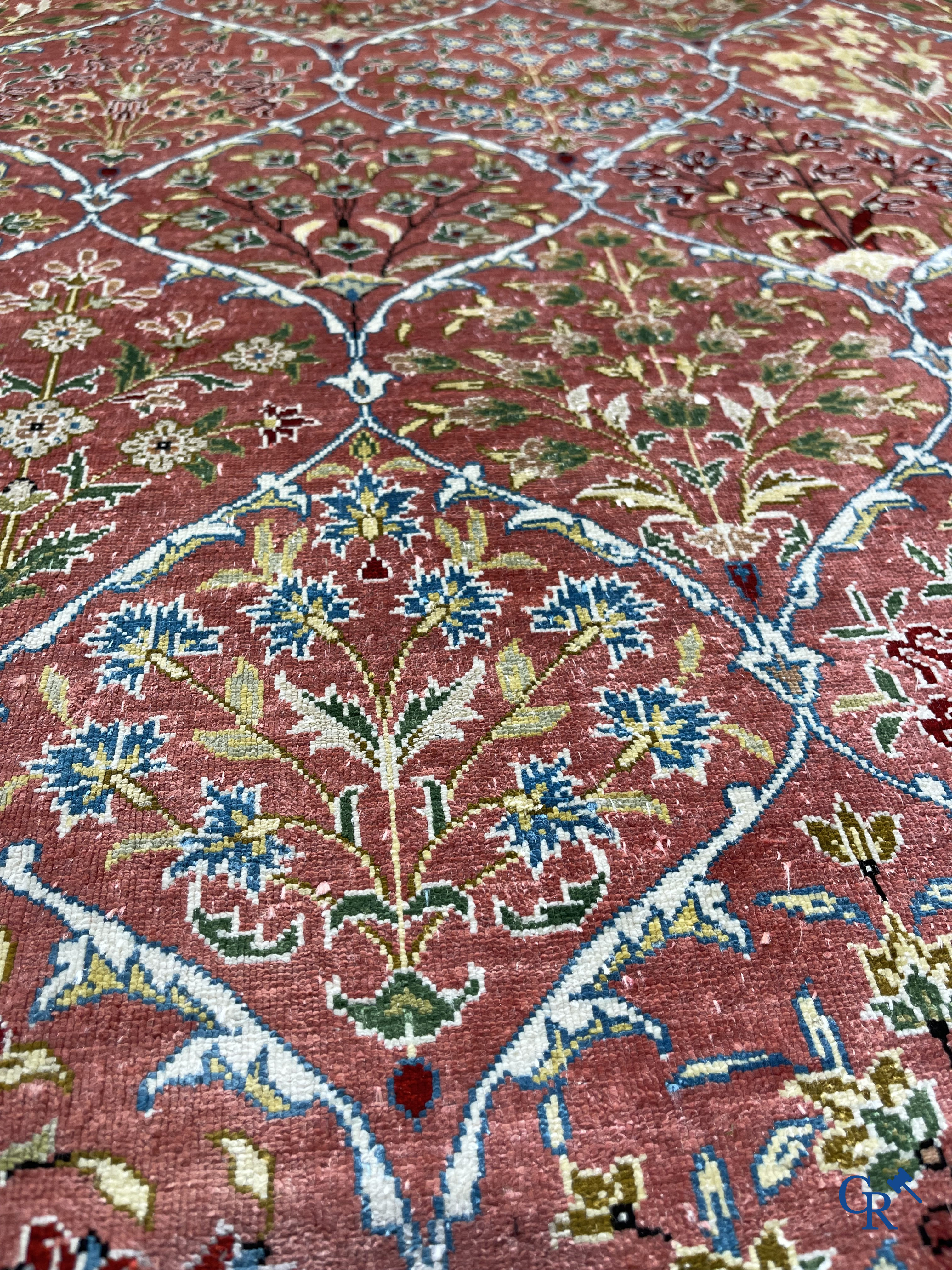 Tapis d'Orient: Un tapis finement noué à la main en laine et soie avec un décor floral.<br />
Signé.