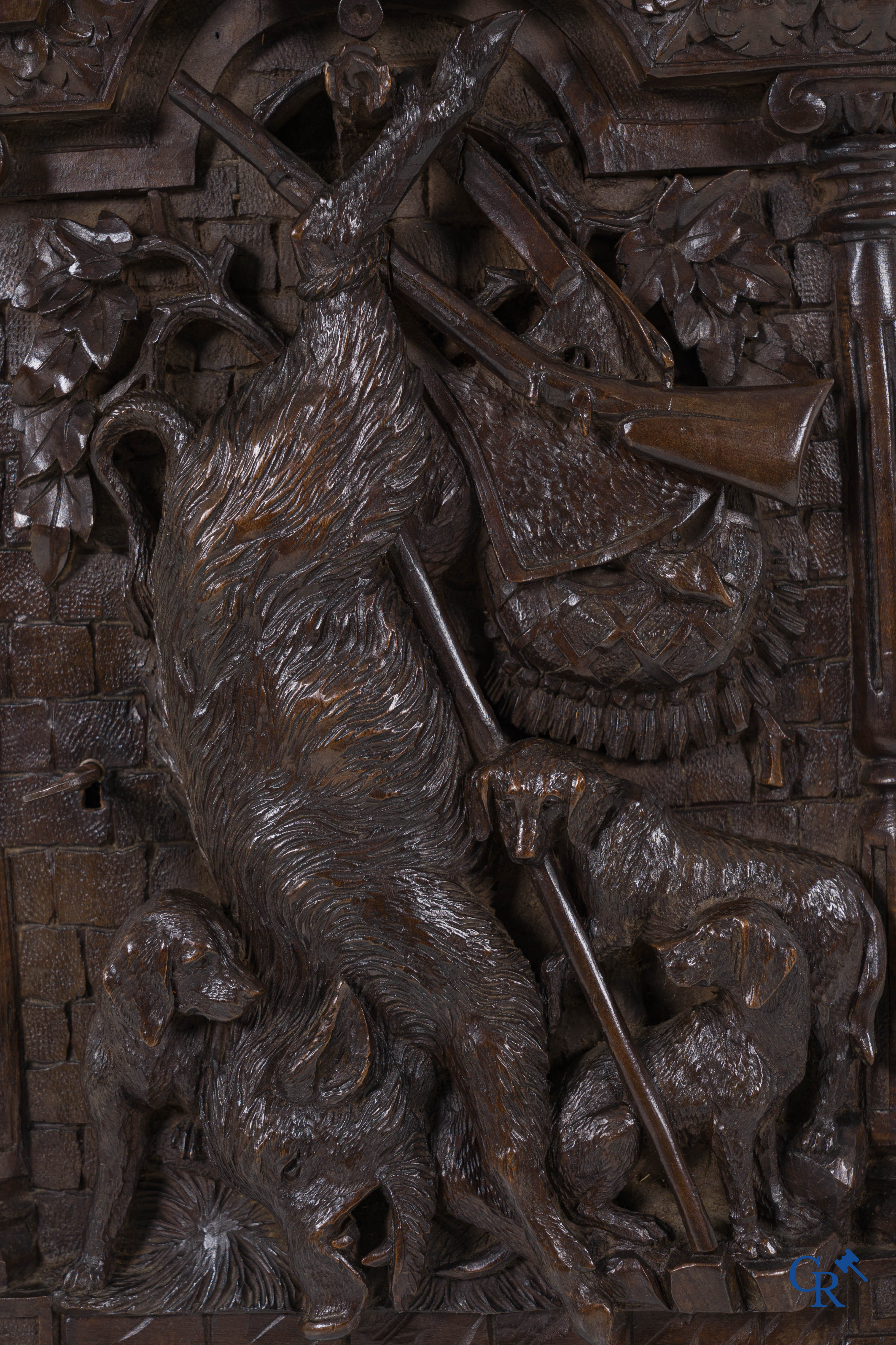 Black forest carvings. Key cabinet in richly sculpted wood with hunting scenes. Circa 1880.