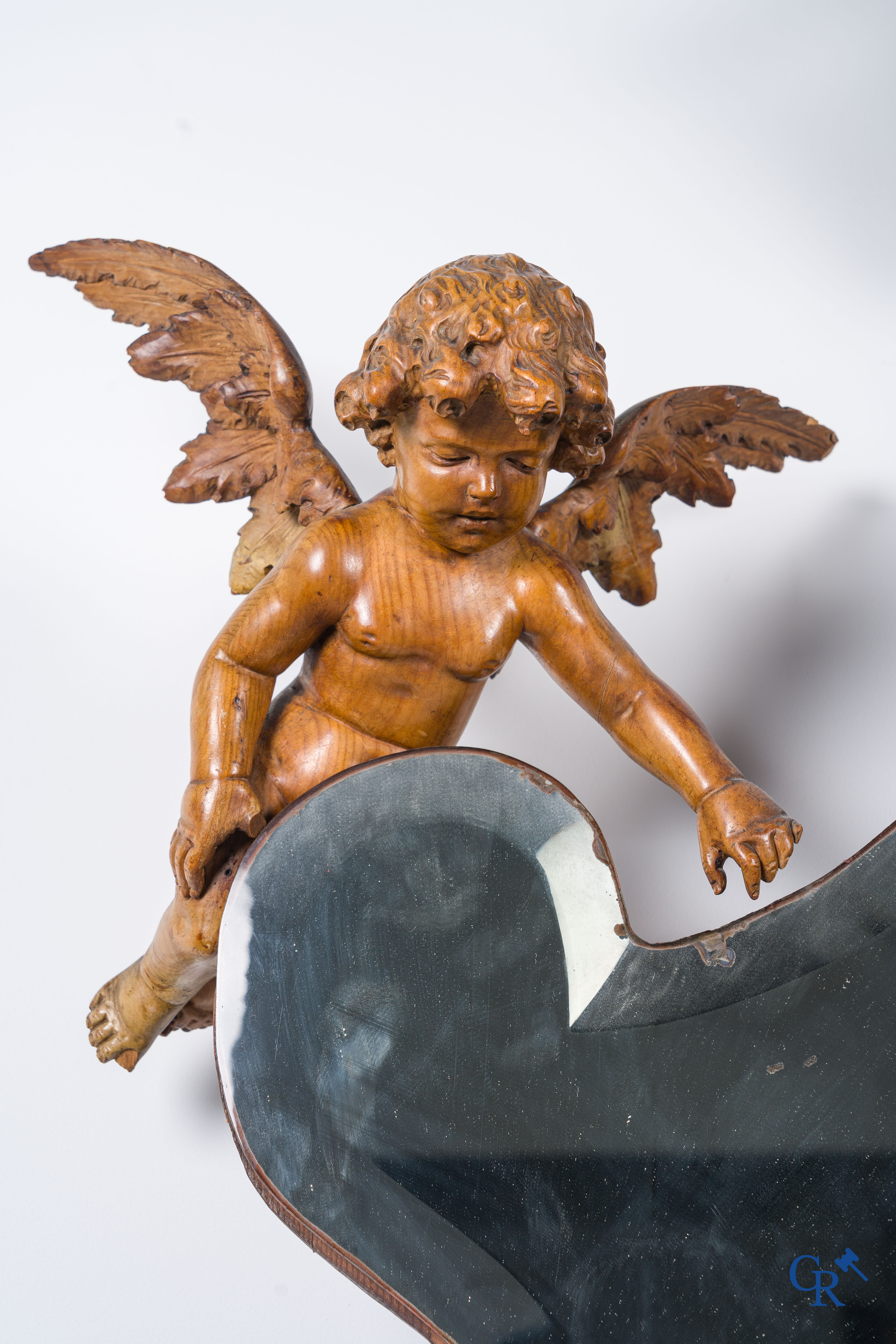 Un grand miroir entouré de 6 putti en bois sculpté. Vers 1900.