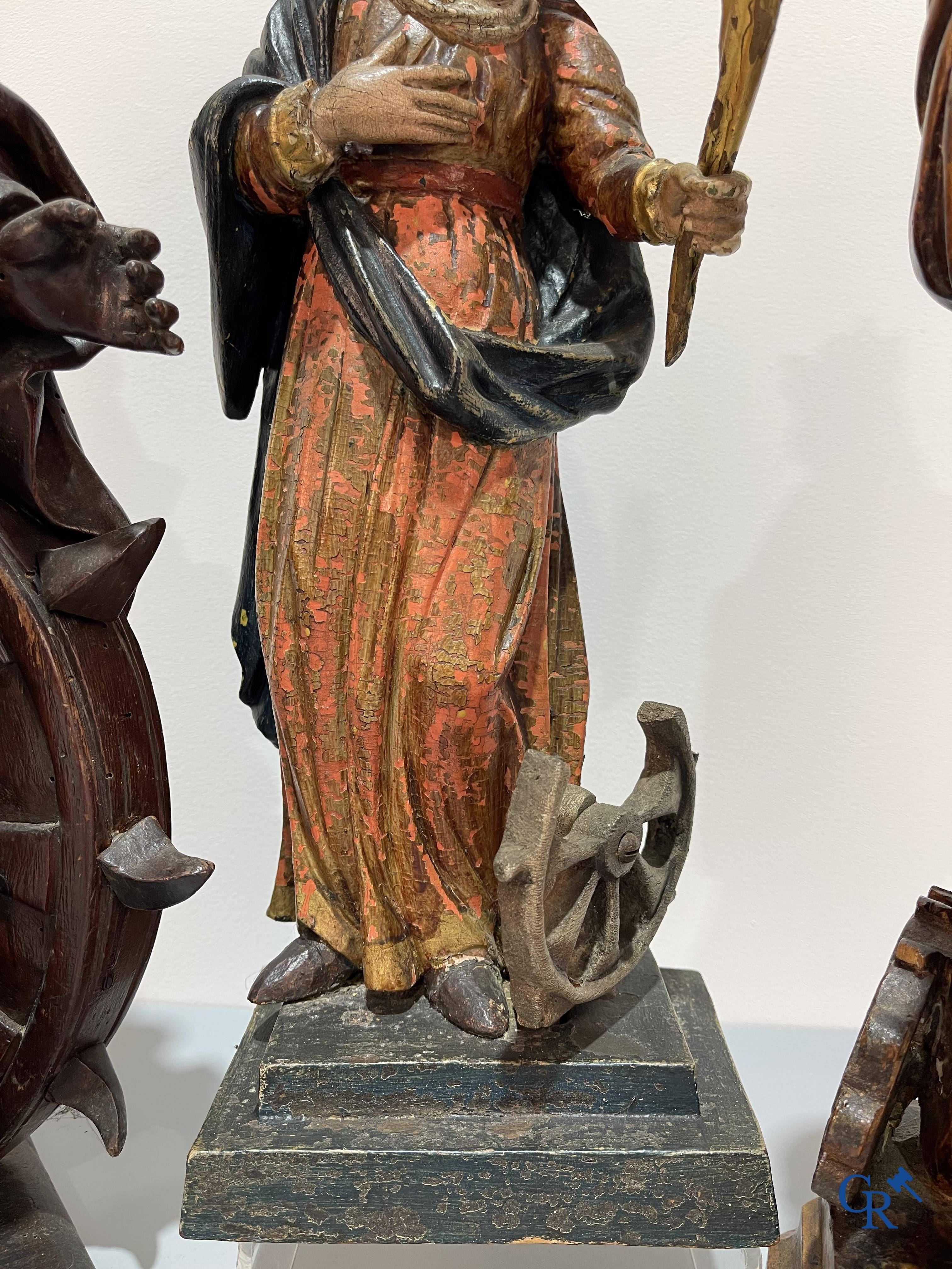 Religieuze objecten, 3 antieke hout gesculpteerde voorstellingen van St. Catharina. 18e-19e eeuw.