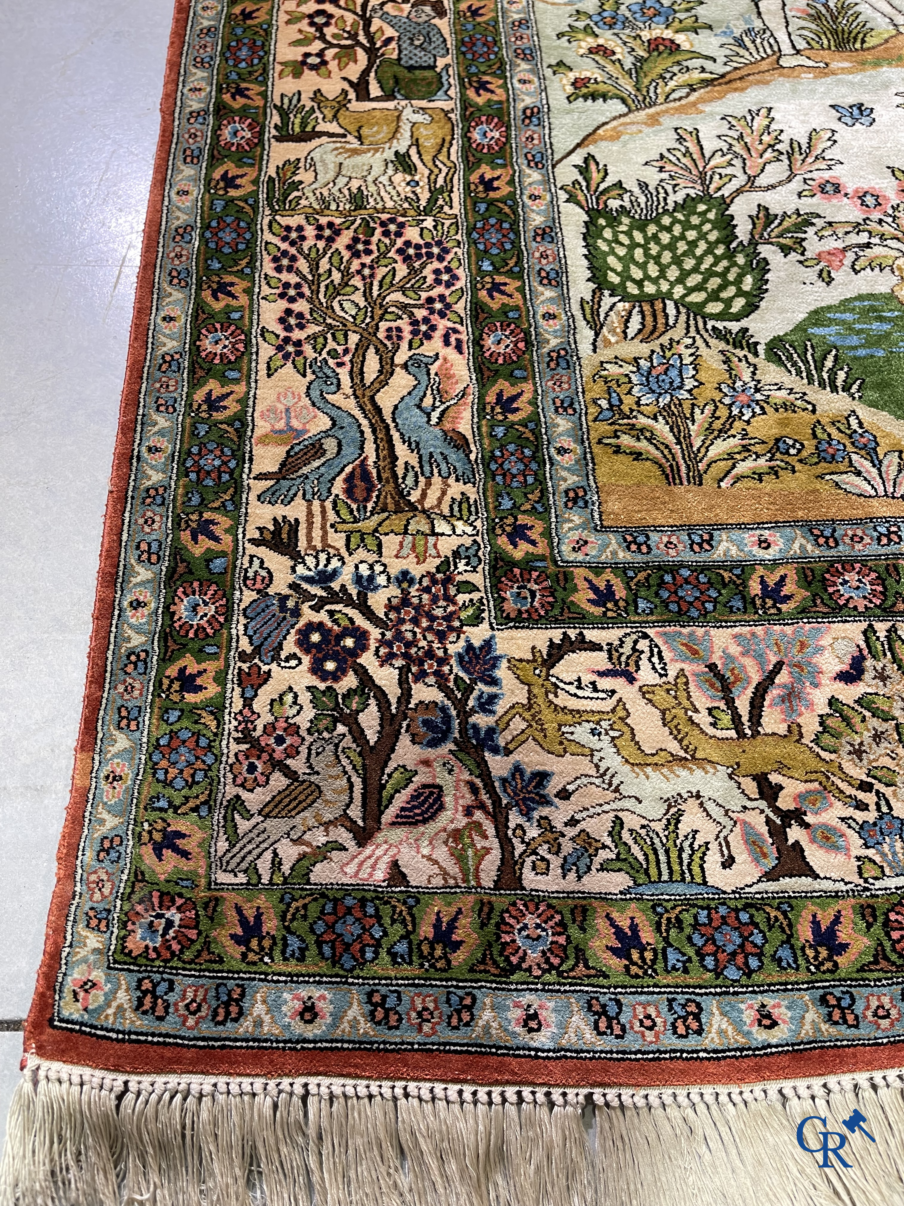 Tapis d'Orient. Iran. Un tapis persan en soie finement noué à la main avec des personnages et un cheval dans un paysage.