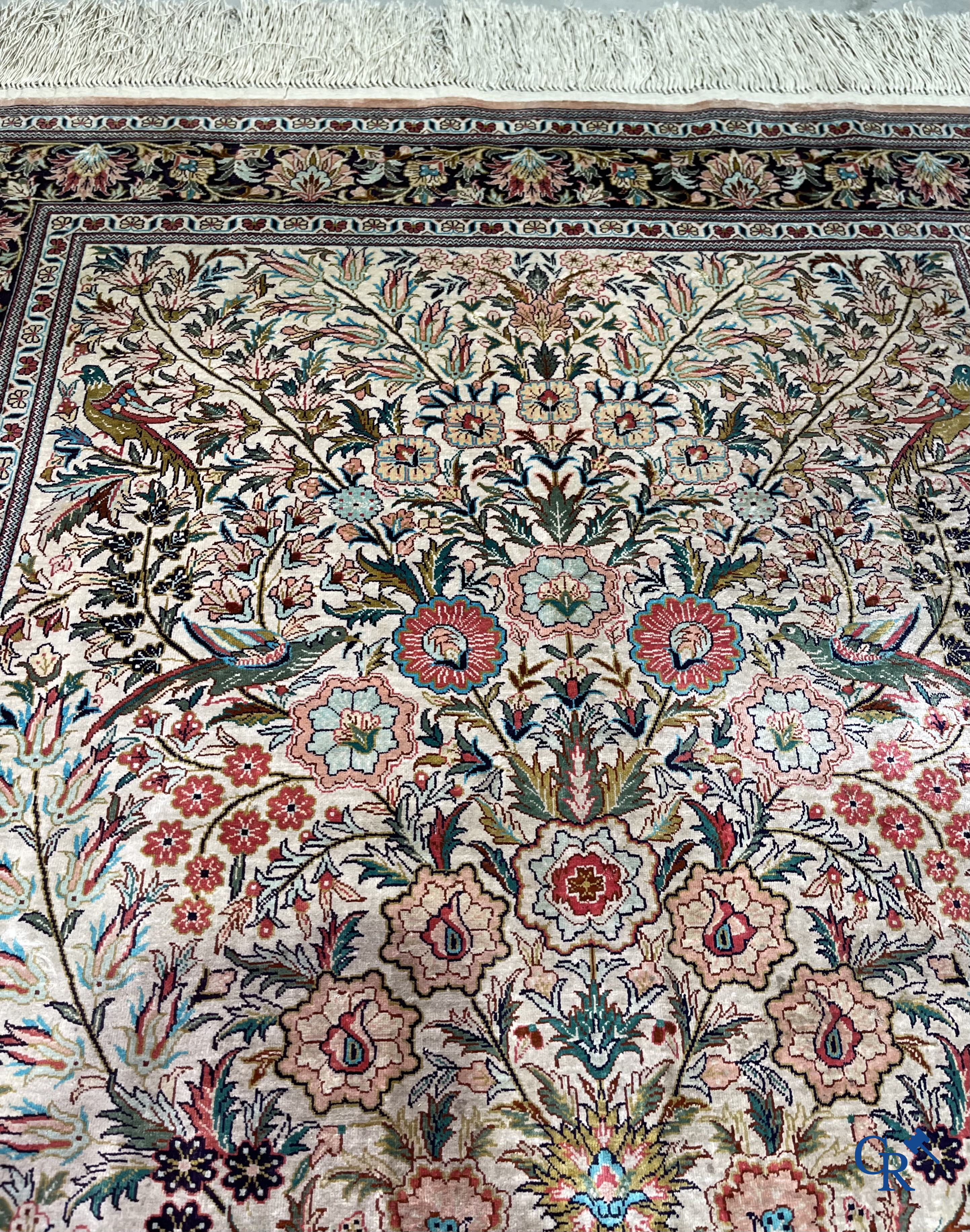 Tapis d'Orient: Un tapis persan en soie finement noué à la main avec un vase à fleurs et des oiseaux dans un décor floral.