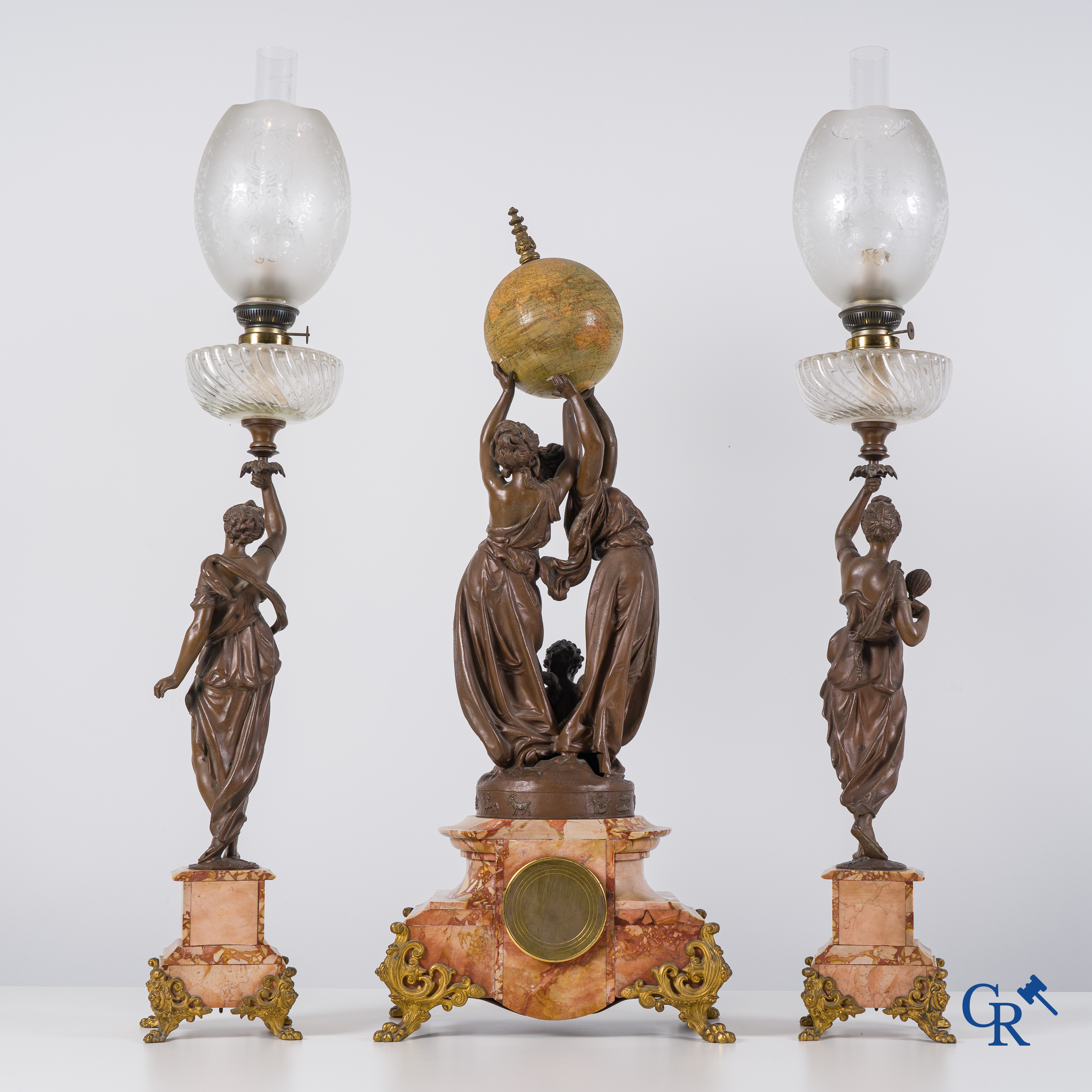 An imposing clock set in marble and spelter, signed Petit, petroleum lamps with glassware in the manner of Baccarat.