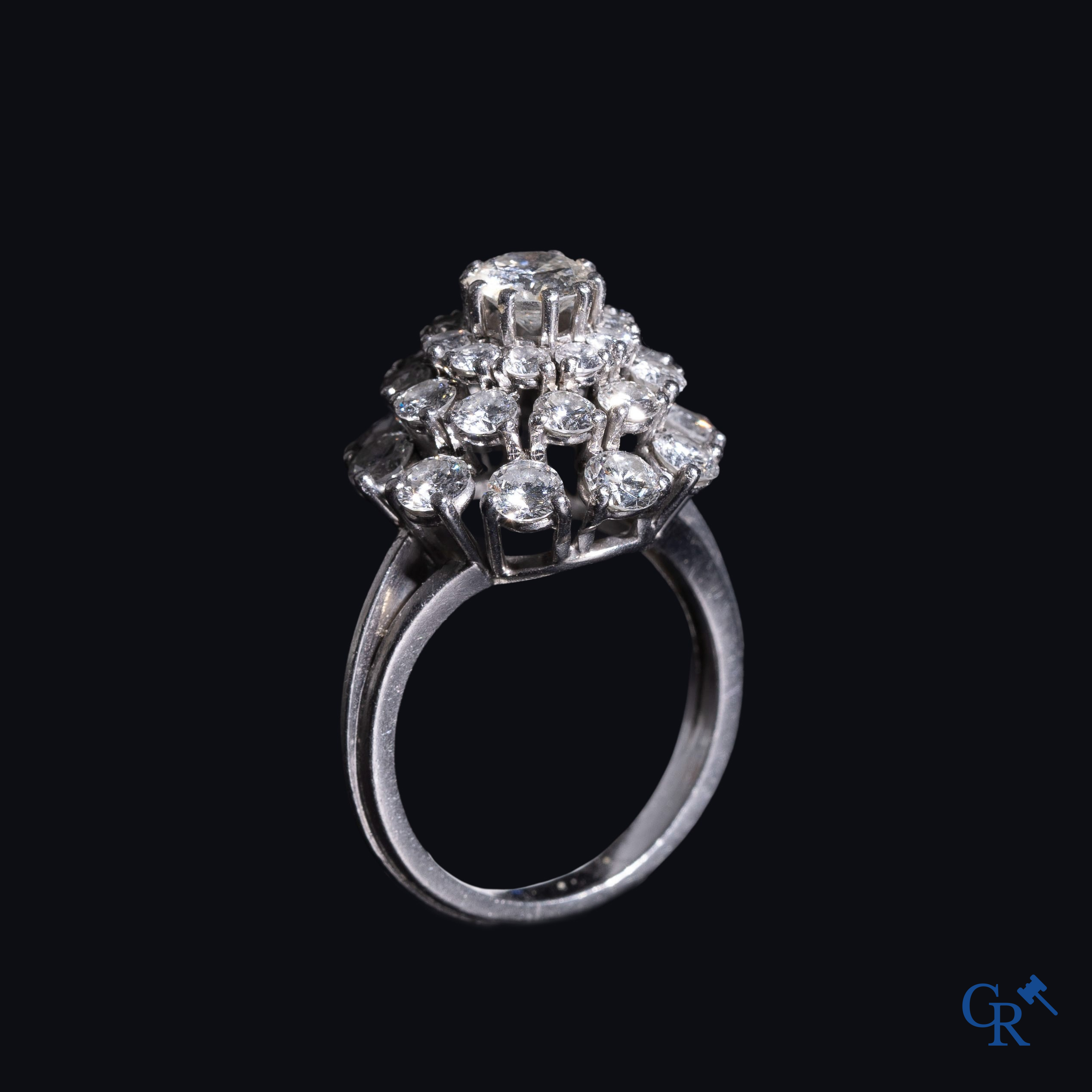 Juwelen: Pompadour ring in Platinum bezet met een centrale diamant van ongeveer 0,75 ct en 30 kleine diamantjes.