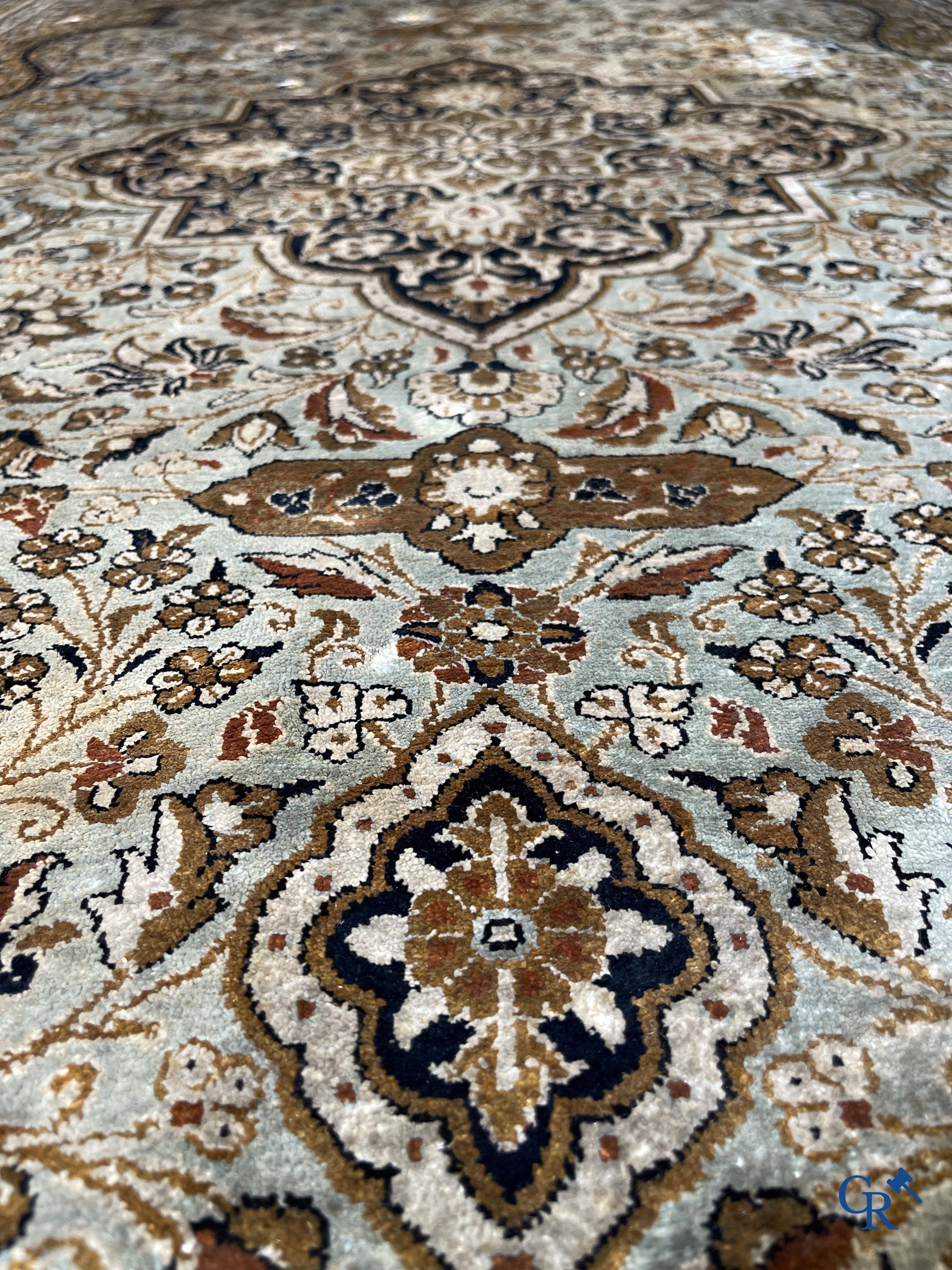 Tapis d'Orient. Un tapis en soie finement noué à la main avec un décor floral.