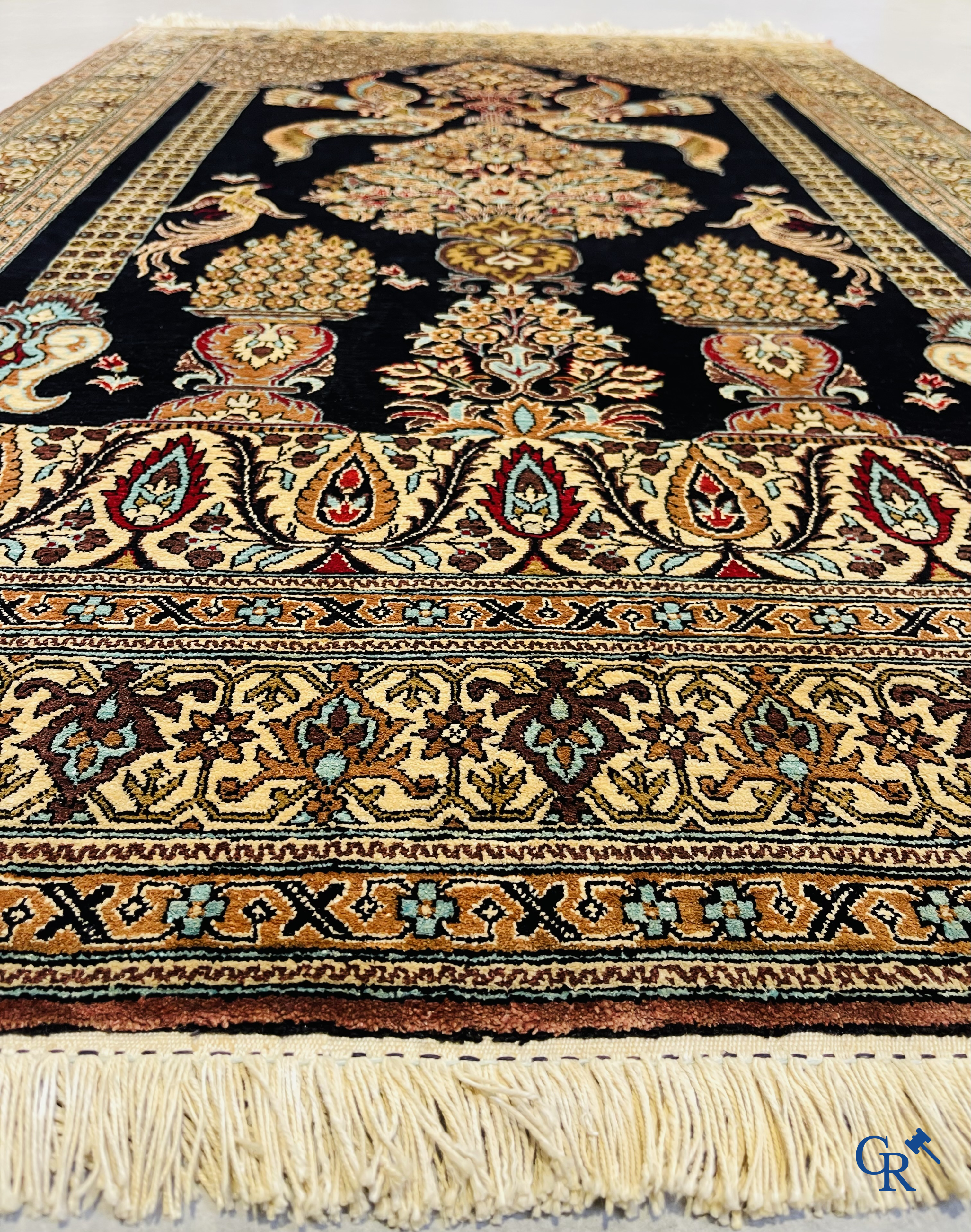 Persian carpets: A finely knotted silk Ghoum carpet with a decor of birds and flowers.