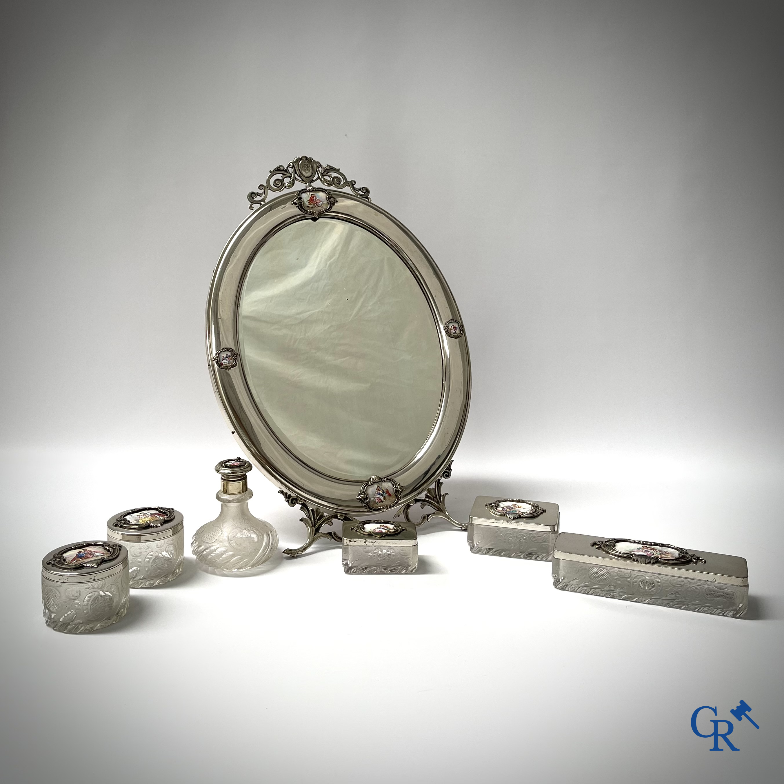 Een 7-delig toiletstel in verzilverd metaal, fijn geslepen kristal en geëmailleerde plaquettes.