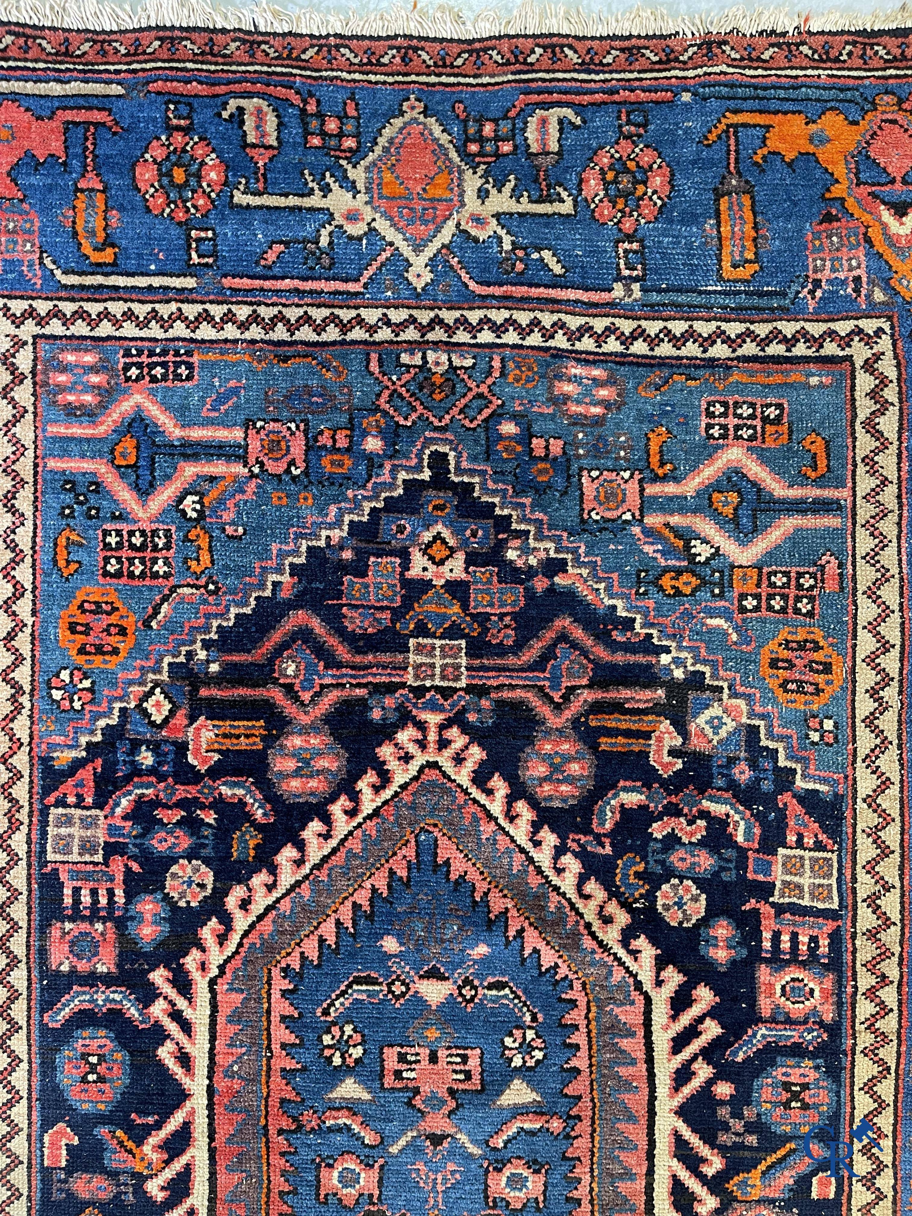 Antique Oriental carpets, an antique hand-knotted carpet with motifs on a blue background.