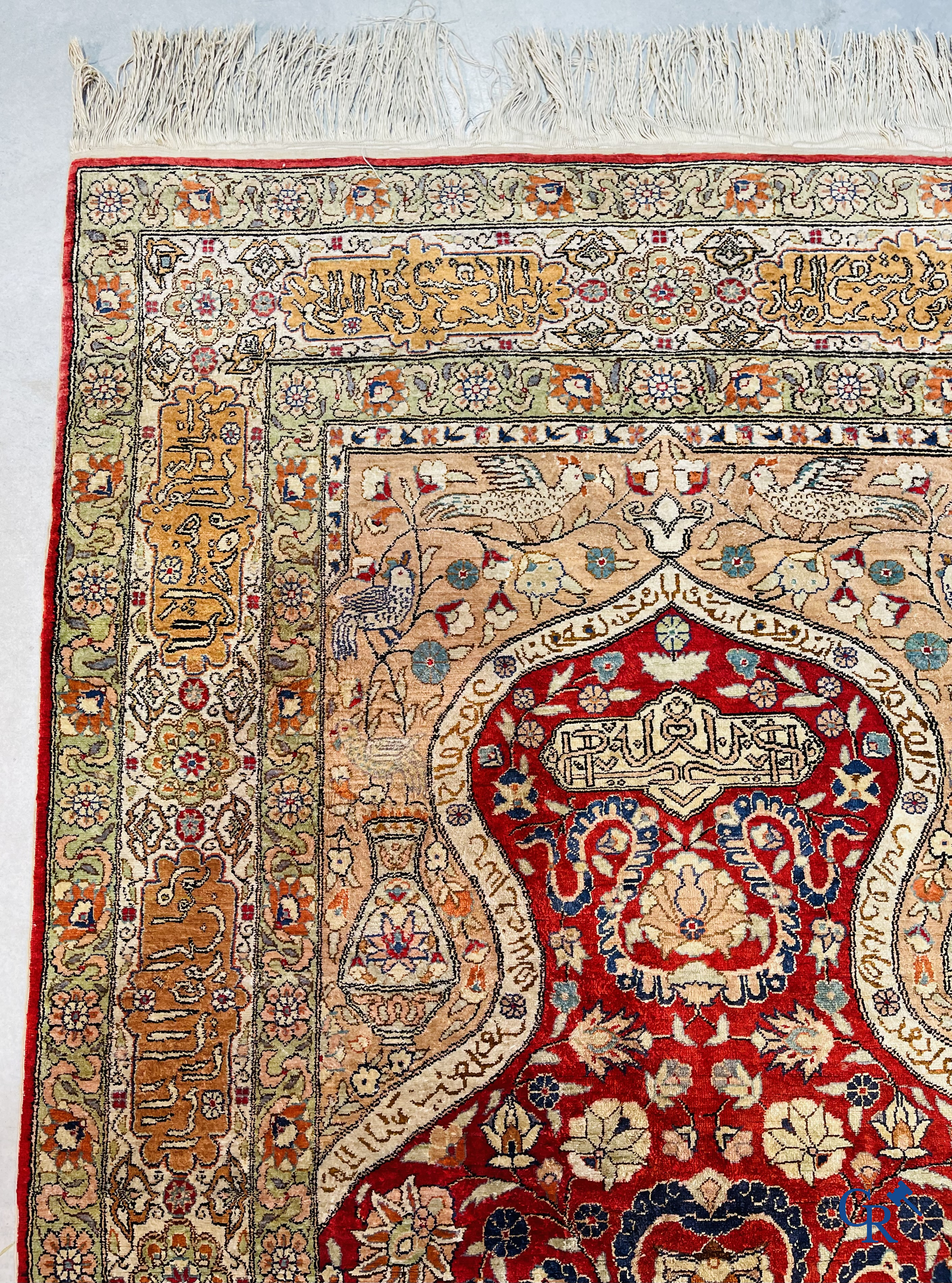 Oriental carpets: Hereke, a finely knotted silk carpet with inscriptions and birds in a floral decor.