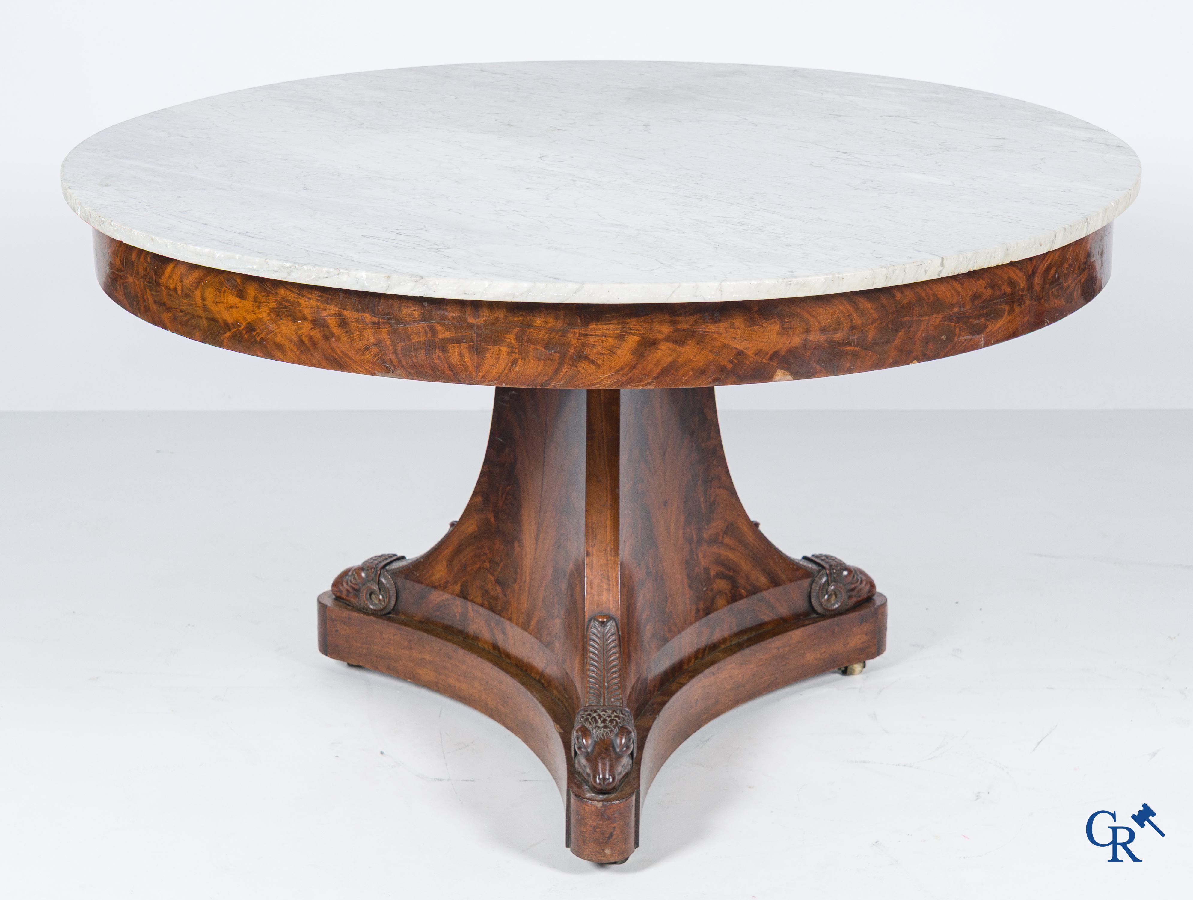 Grote ronde drie-potige tafel met ramskoppen in mahonie hout en wit marmer blad. Empire periode. 1ste kwart 19e eeuw.