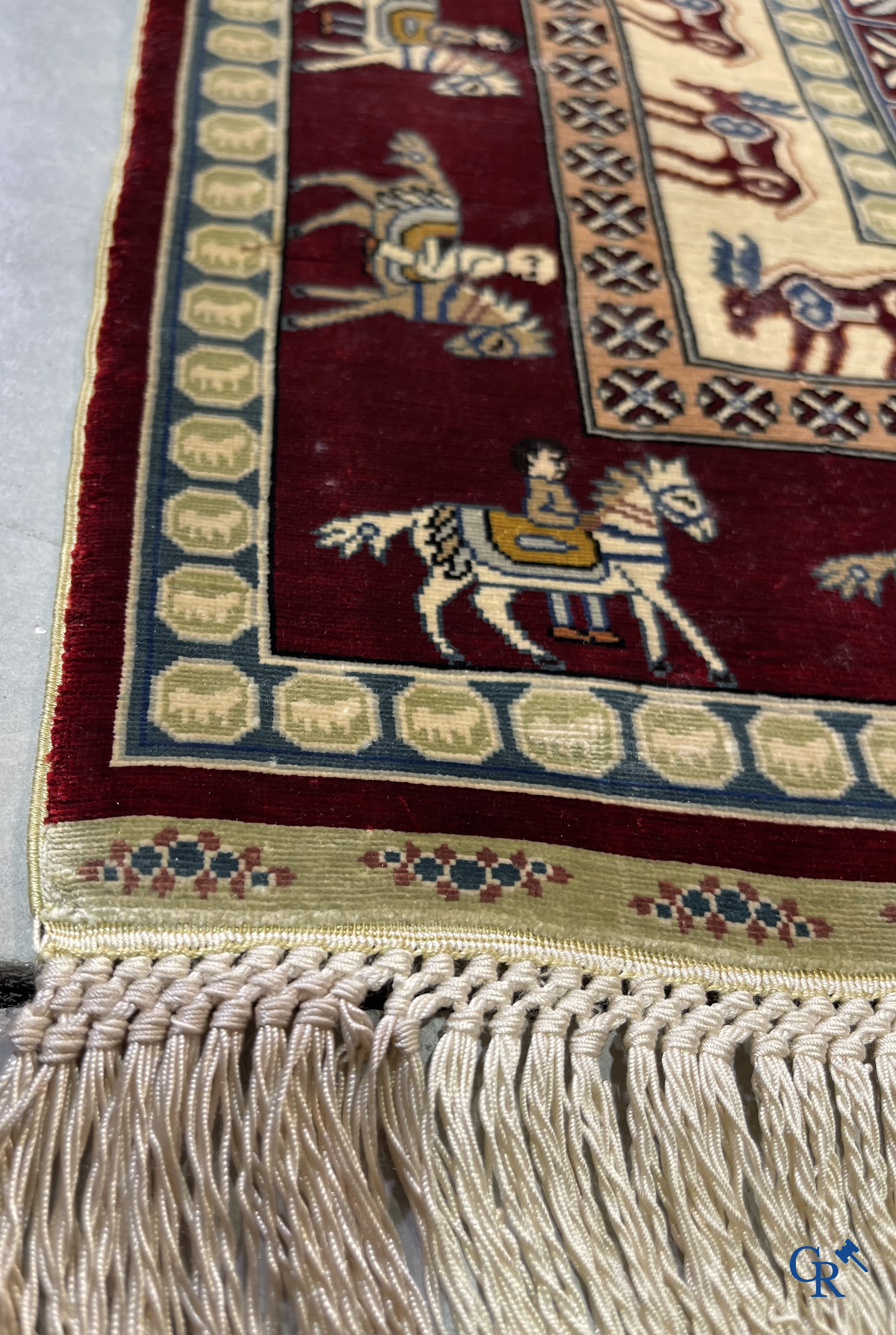 Oriental rugs: A small finely hand-knotted silk rug with deer and horsemen. Signed.