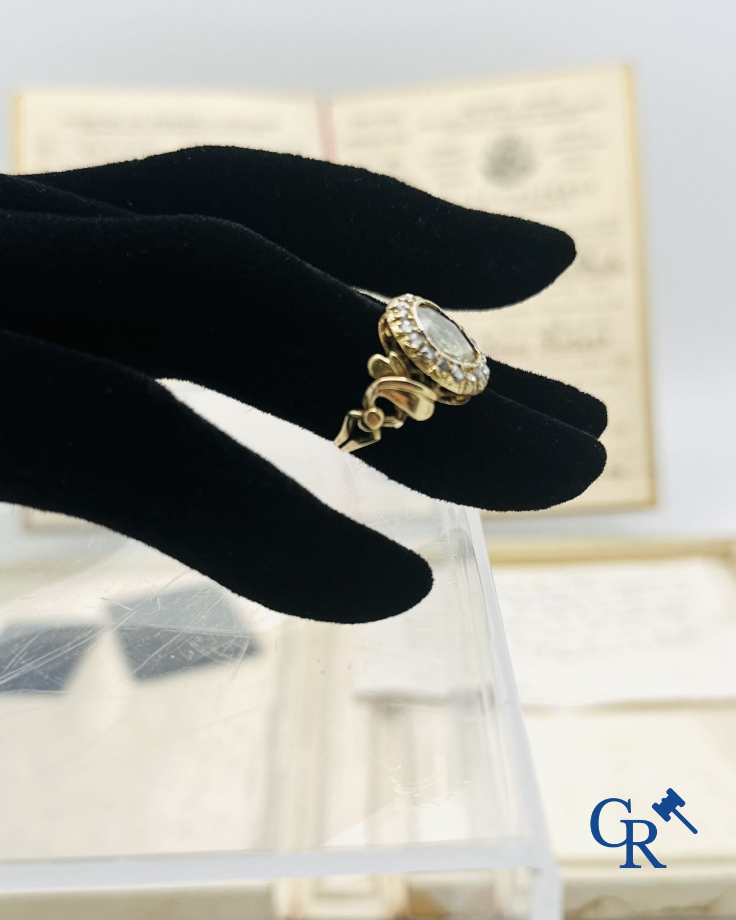 Juweel: Ring in goud 18K bezet met een grote diamant en 16 kleine diamantjes.