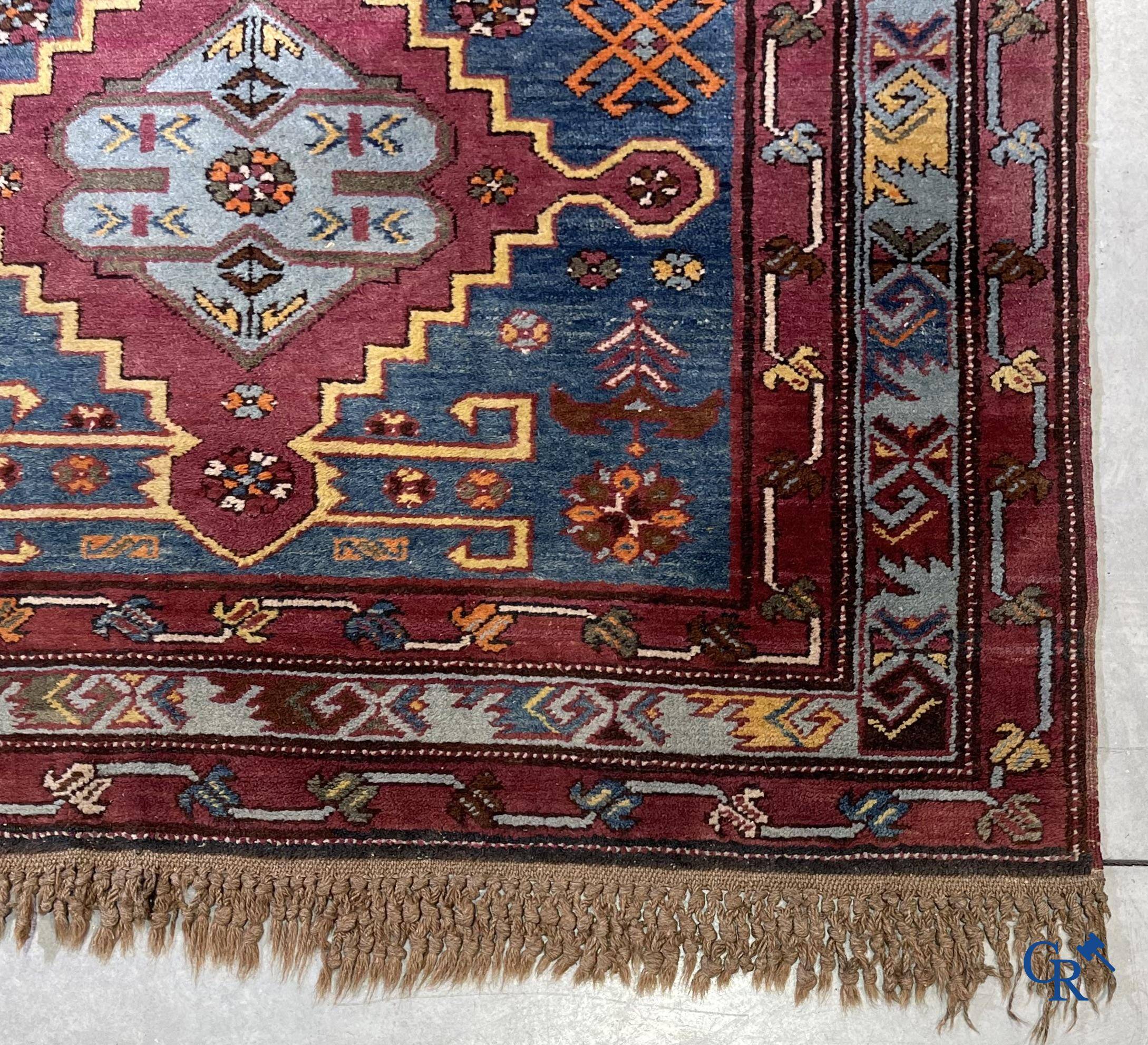 Oriental carpets, an antique hand-knotted Oriental carpet with motifs on a blue background.