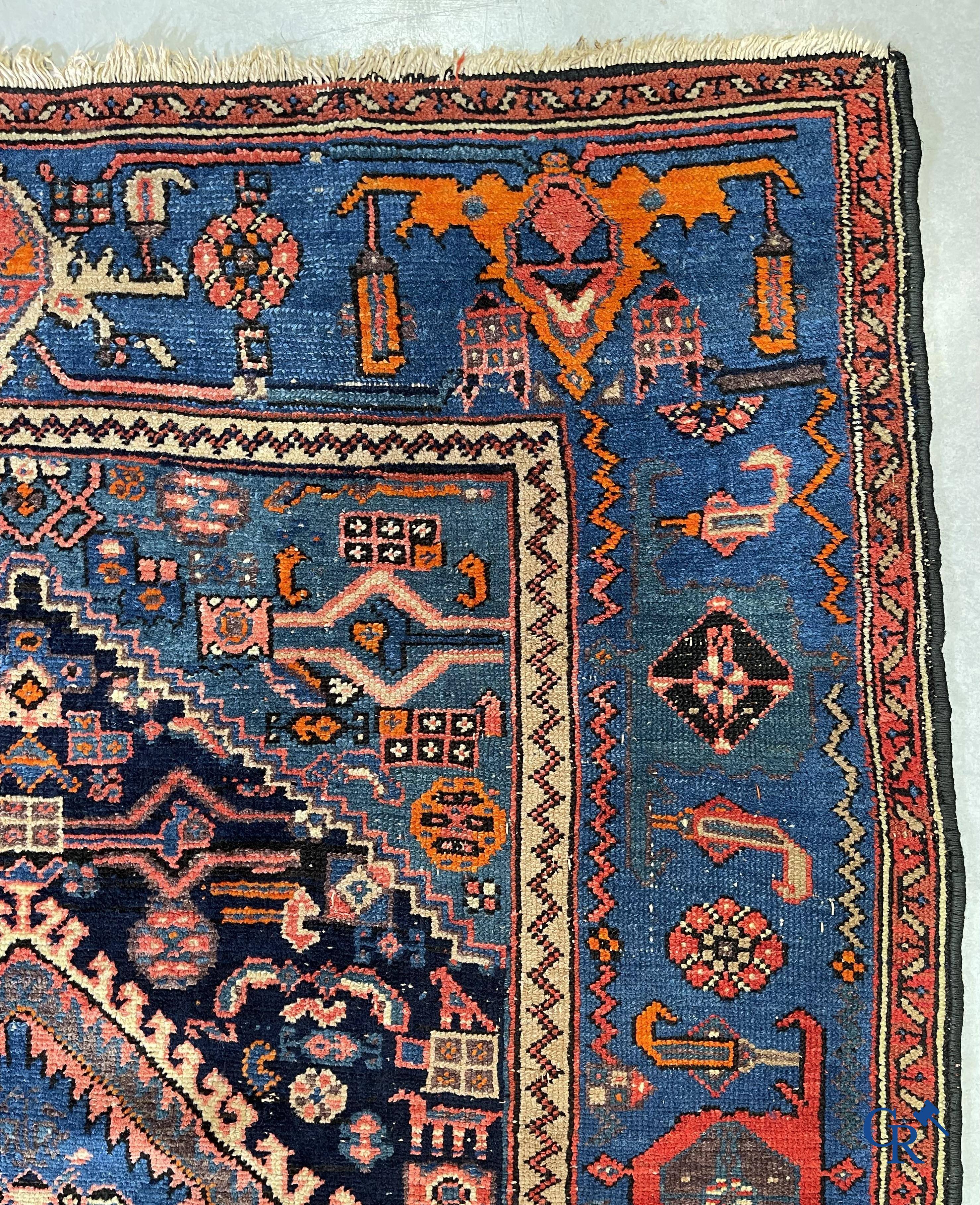 Antique Oriental carpets, an antique hand-knotted carpet with motifs on a blue background.